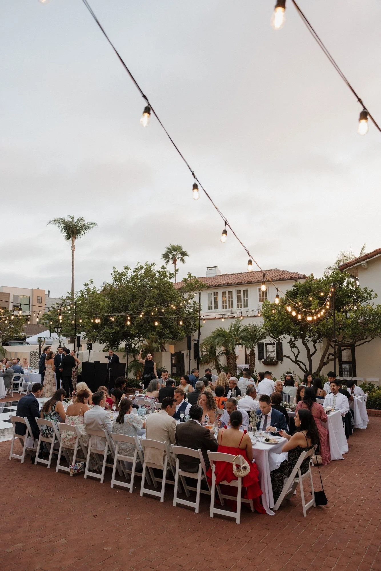 Wide view of Ryan and Sean's reception dinner under string lights at Darlington House