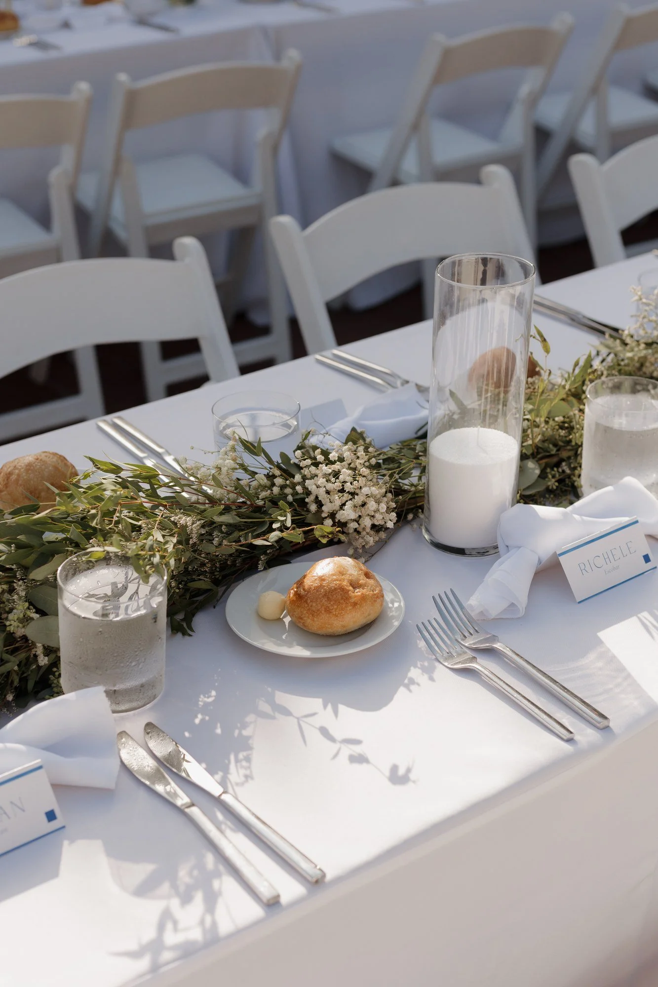 Place setting with greenery garland and candles at Ryan and Sean's reception