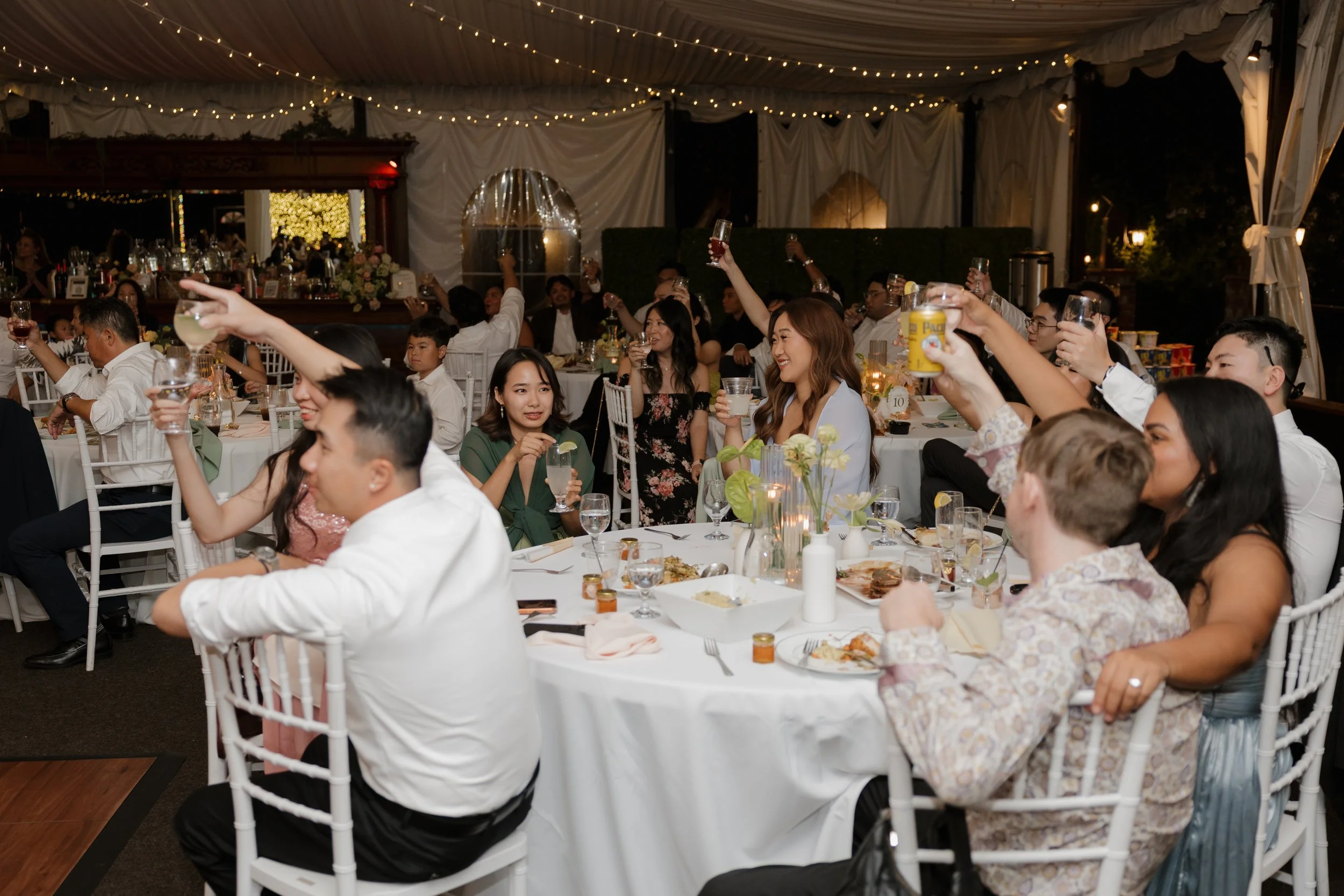 Guests raising their glasses during toasts at Nancy and Ken's San Marcos wedding reception