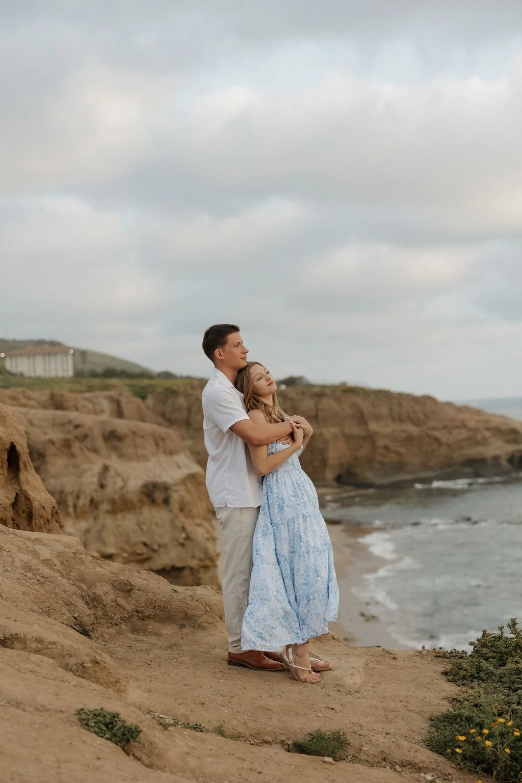 Couple embracing on the bluffs at Sunset Cliffs