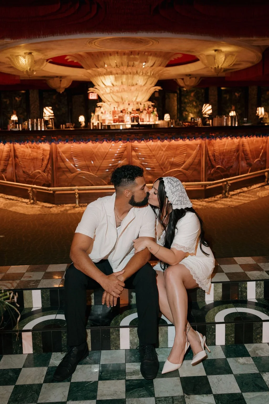 Couple seated at a glamorous bar with a checkered floor at the Lafayette Hotel