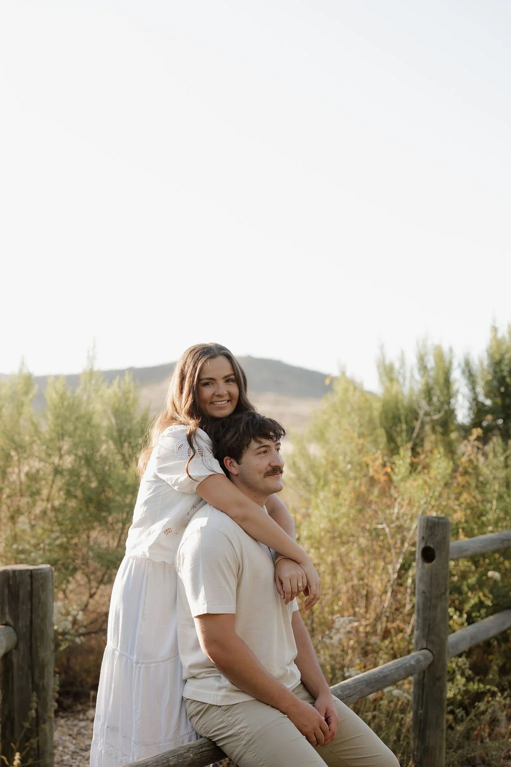Playful piggyback moment by a wooden fence at Mission Trails