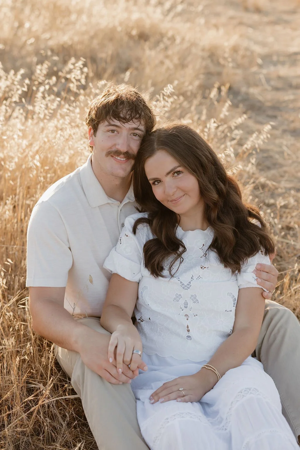 Close portrait of a couple sitting in golden grass at Mission Trails