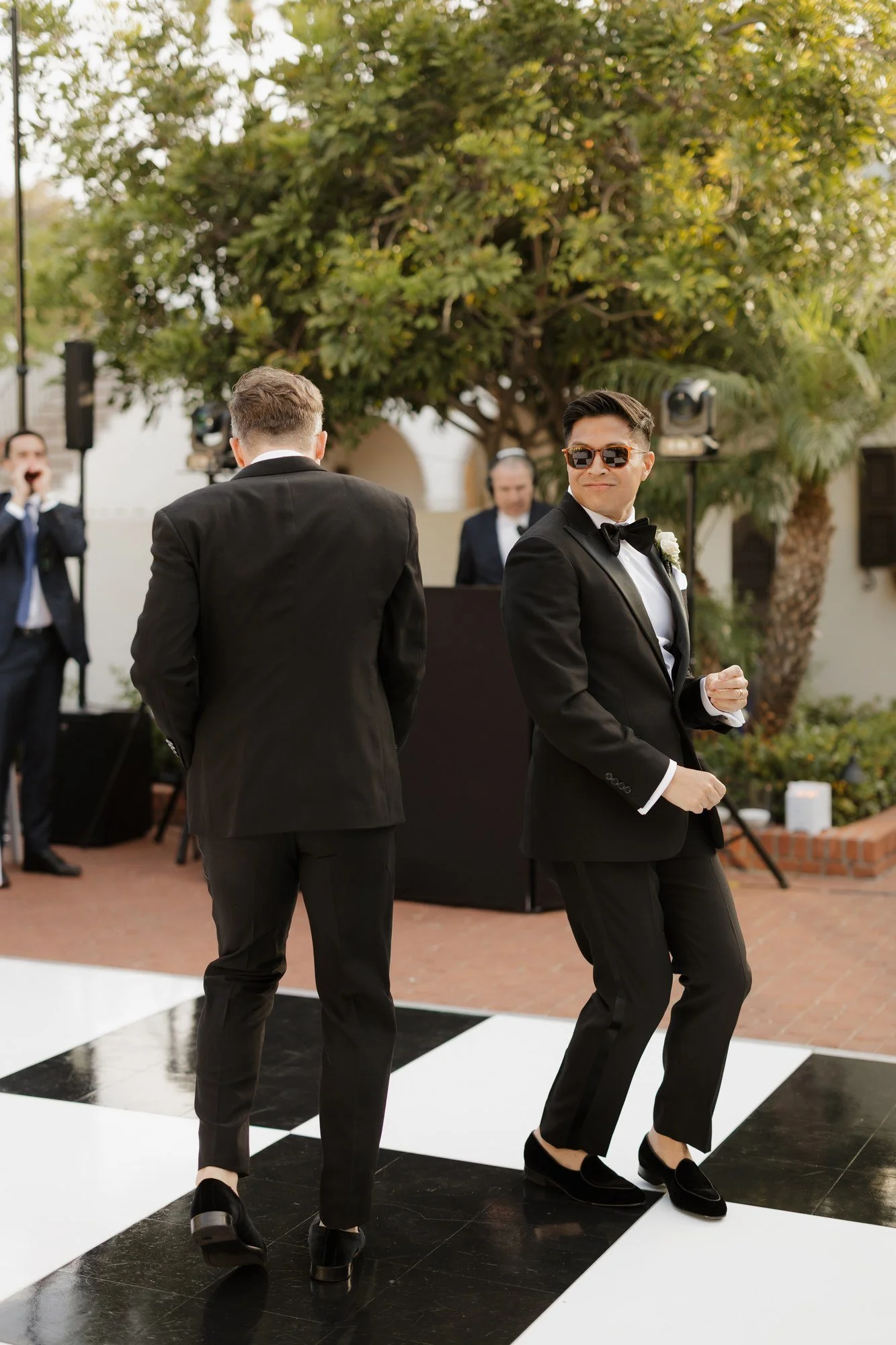 Ryan and Sean dancing onto the checkerboard dance floor for their reception entrance