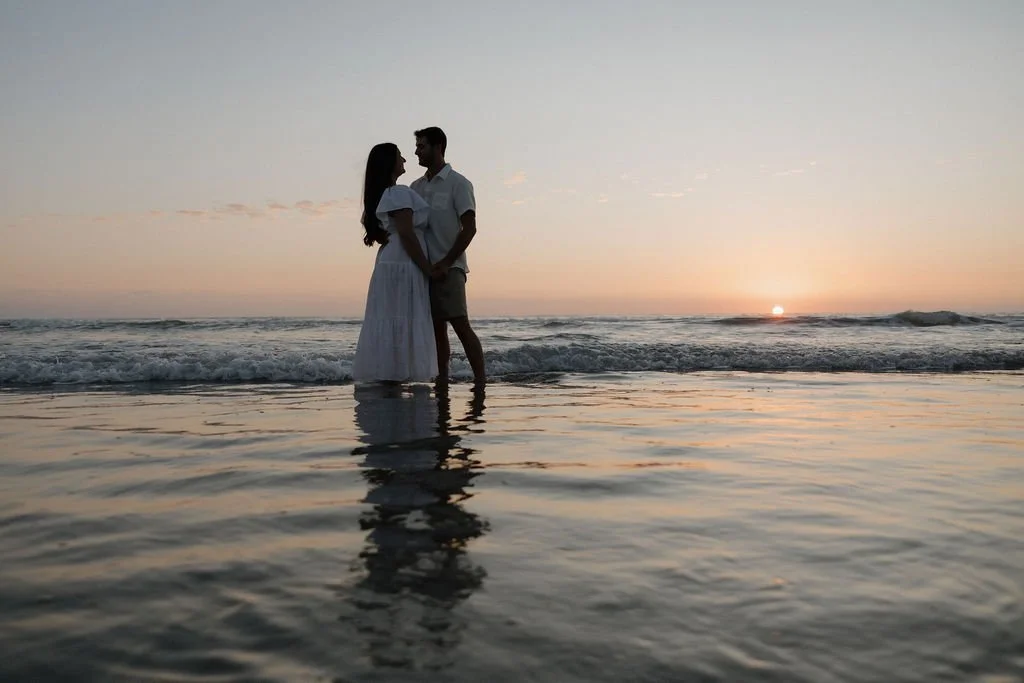 Sunset silhouette of a couple in the tide at Torrey Pines State Beach