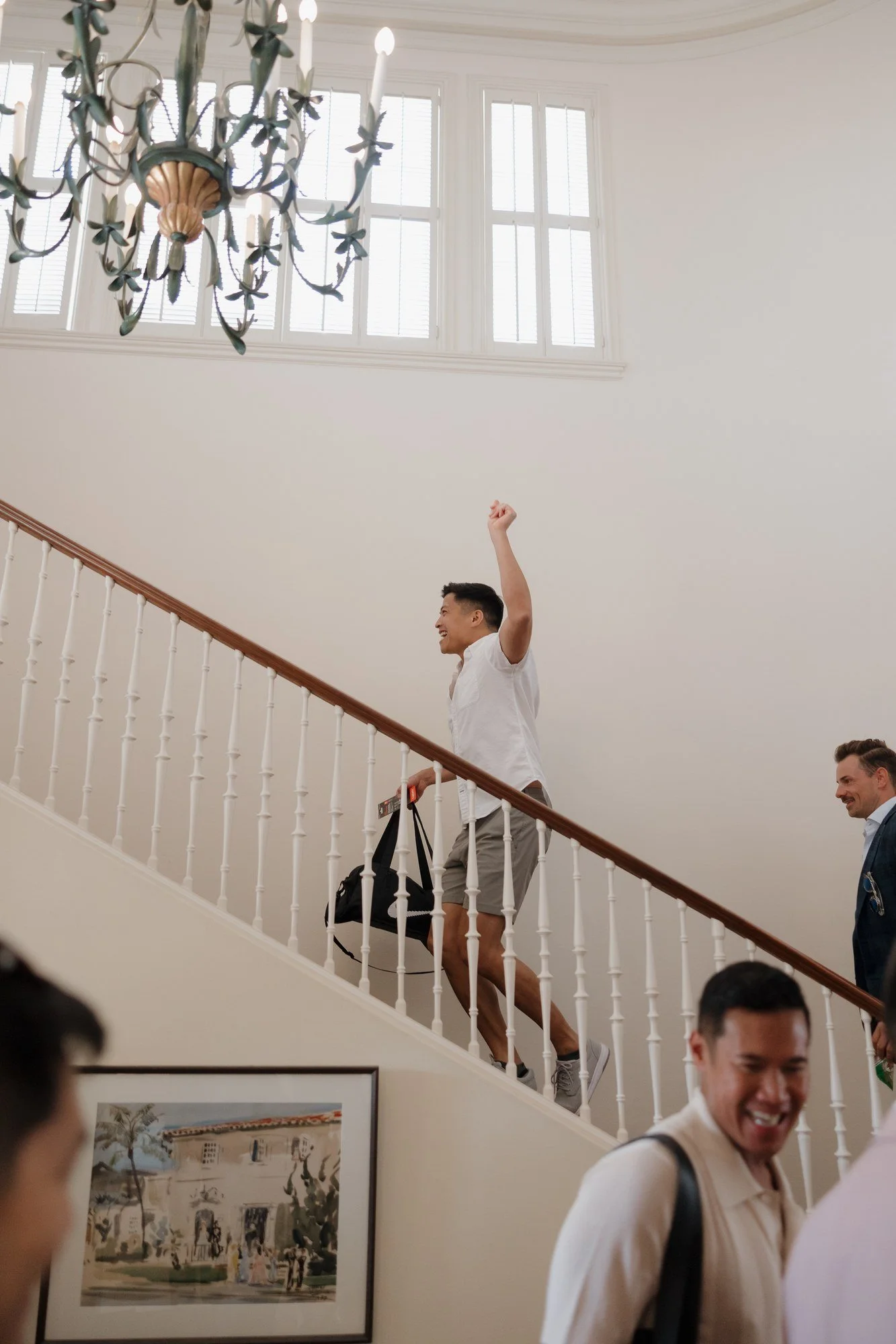 Groom's party cheering on the staircase while getting ready at Darlington House