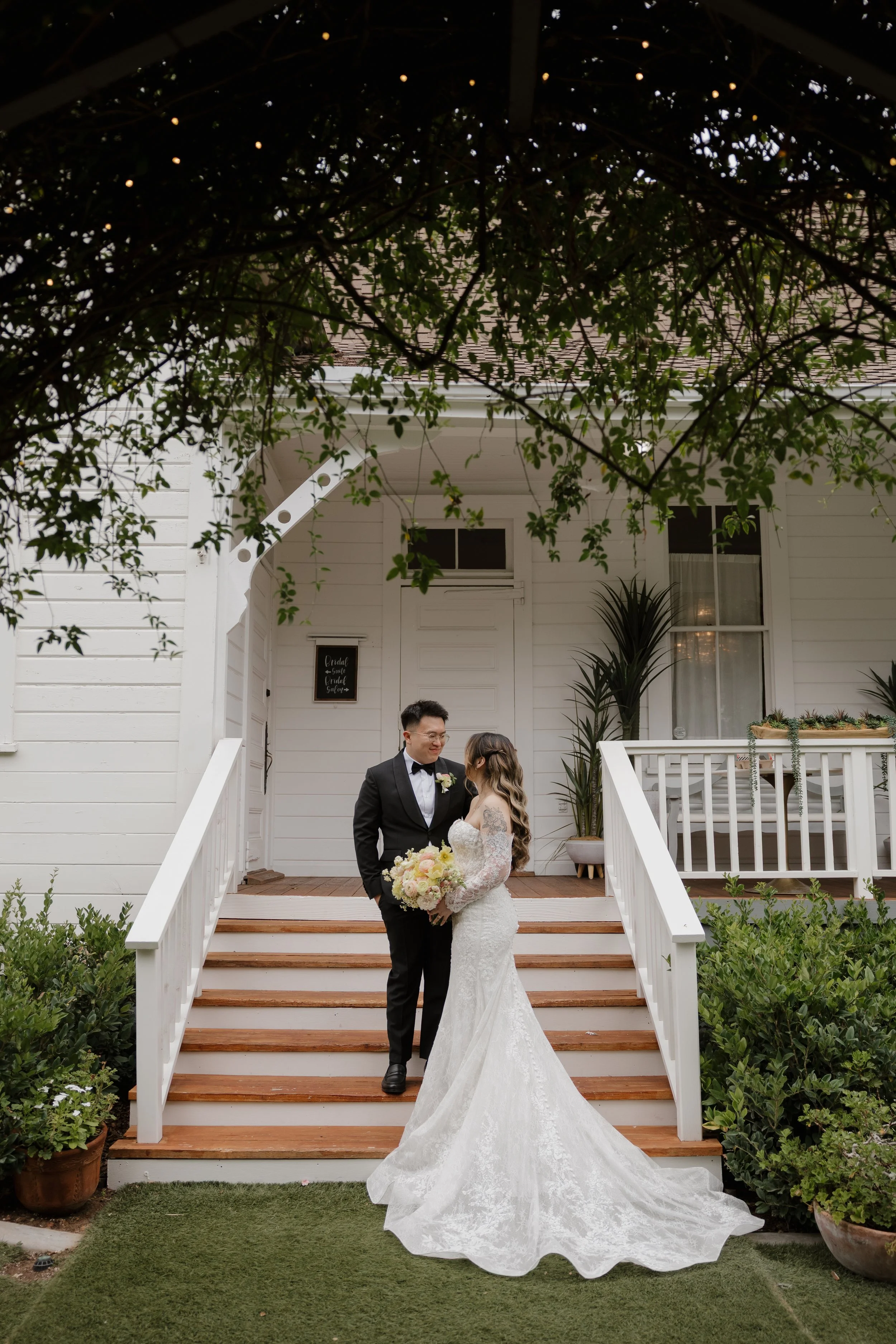 Nancy and Ken on the steps of the white schoolhouse at Green Gables Wedding Estate