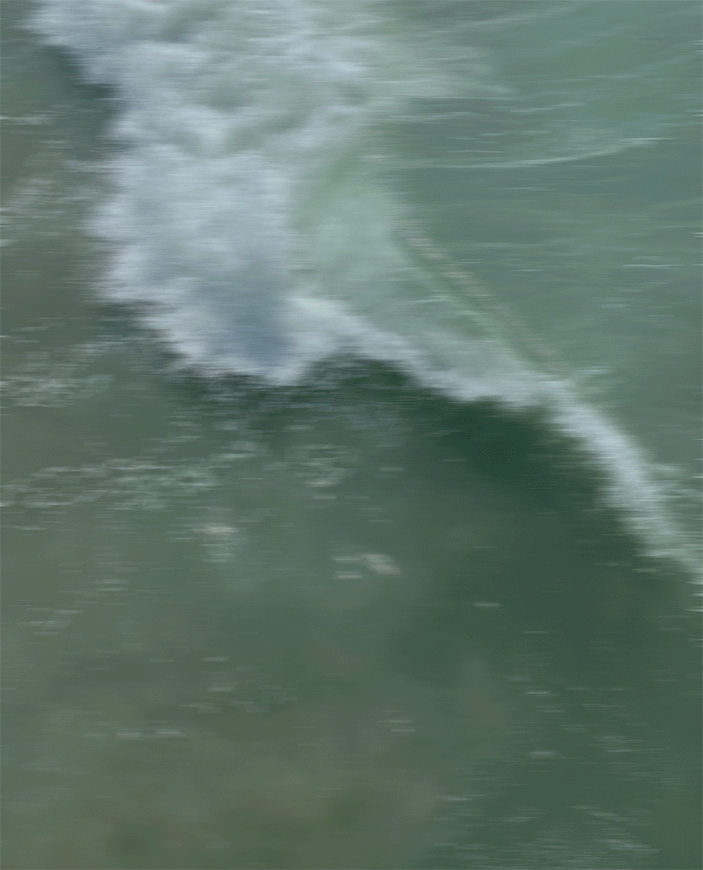 A person riding a jet ski on the water, creating a large splash and wake behind them.