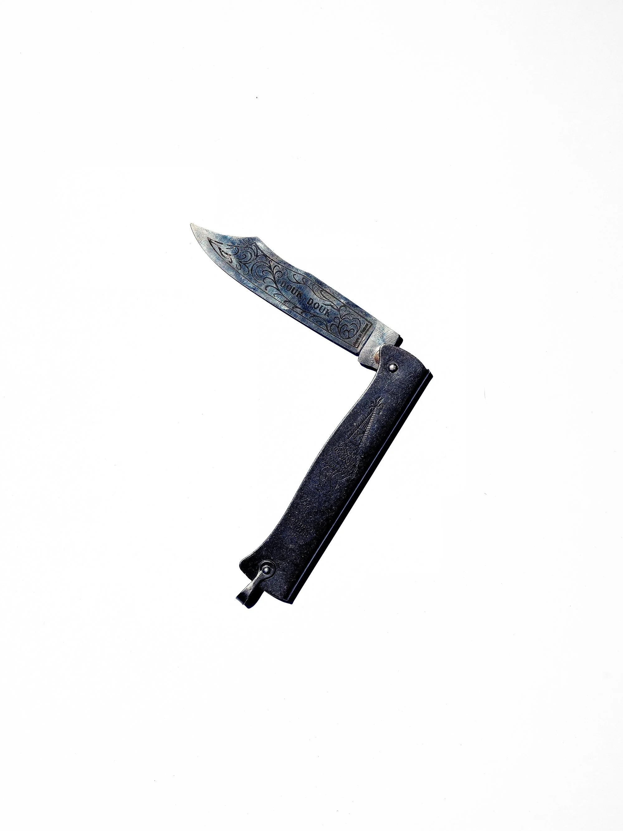 Engraved folding knife with open blade on white background