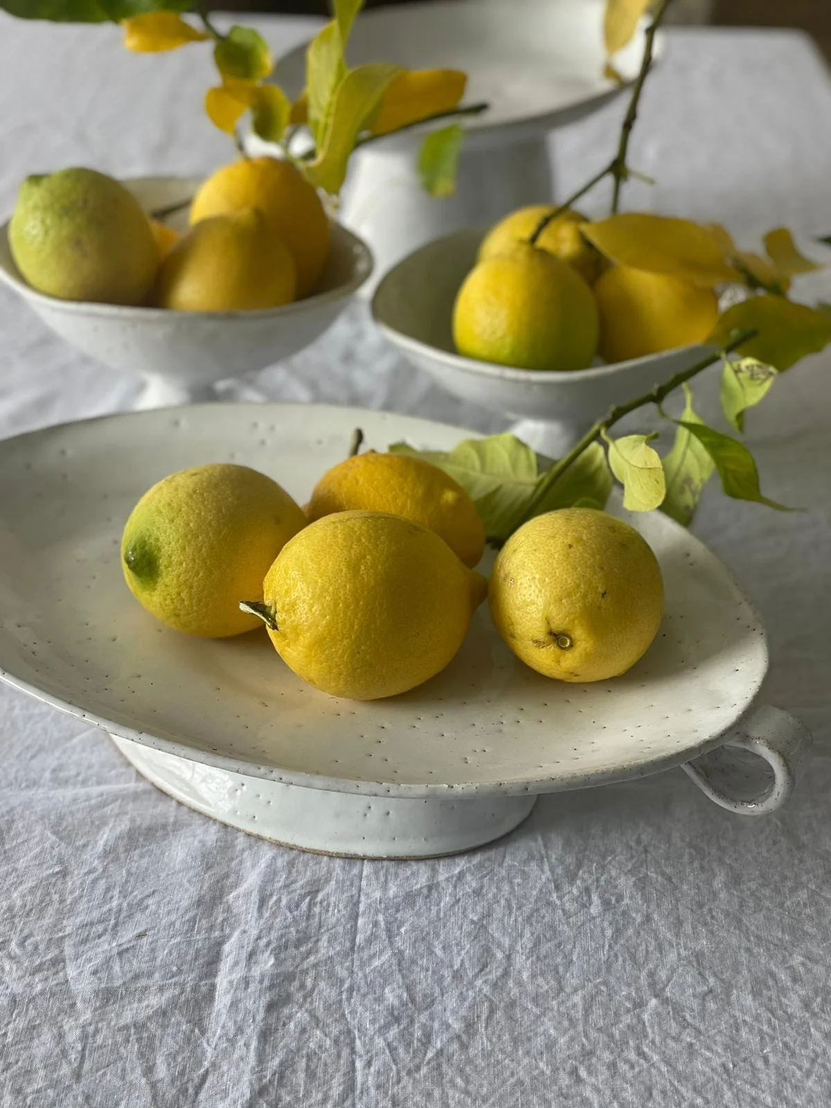The Rome XL Oval Pedestal Serving Platter by Melissa Lellouche is a handcrafted ceramic centrepiece with a raw natural glaze. Perfect for serving, entertaining, or elegant display.