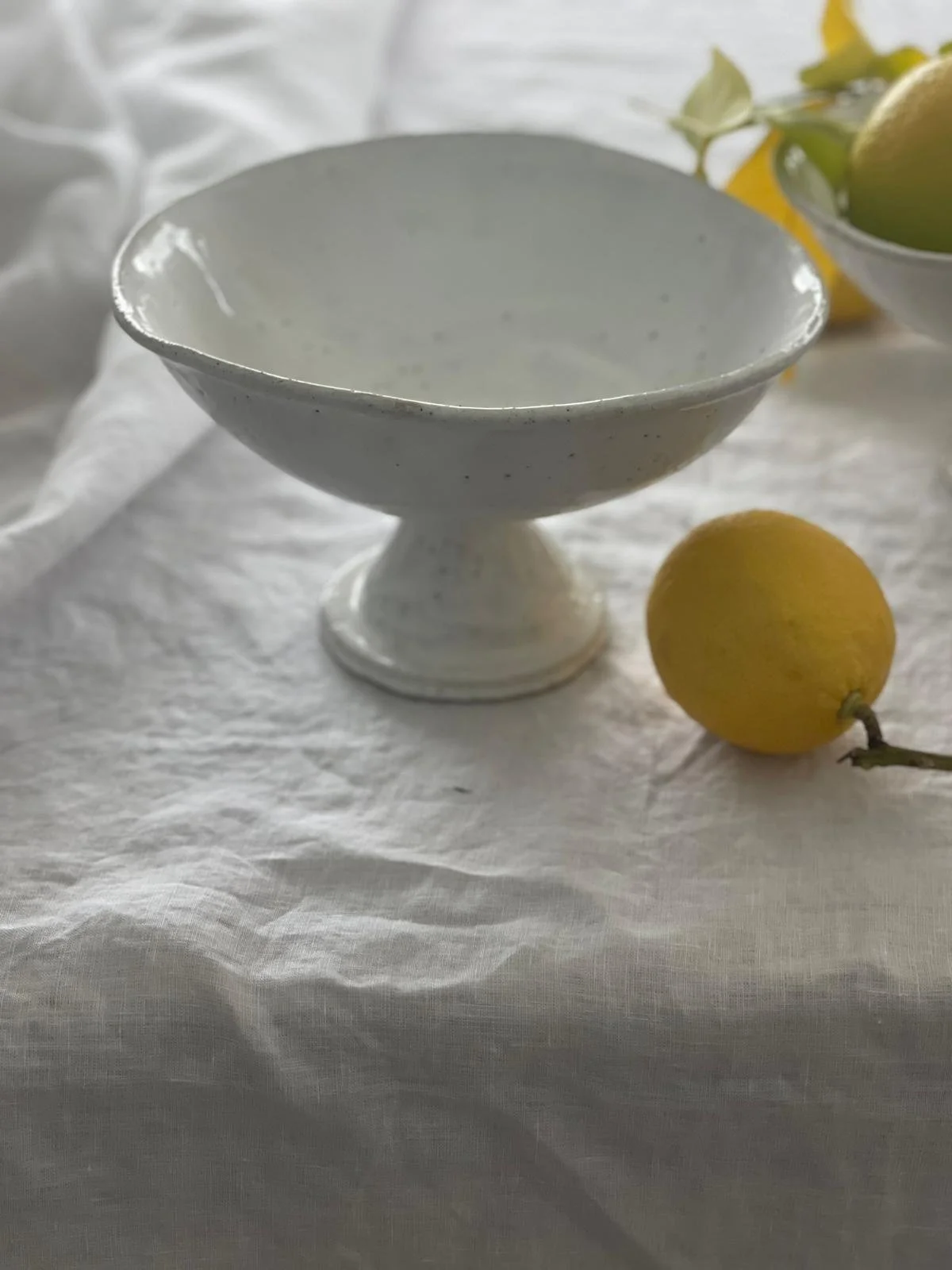 Rome Fruit Pedestal Bowl – handcrafted ceramic pedestal bowl by Melissa Lellouche with natural raw glaze and sculptural base. Ideal as a fruit bowl or centrepiece.