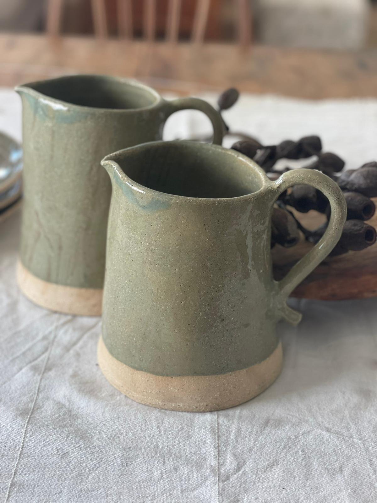 Handmade Olive Green Medium Ceramic Jug by Melissa Lellouche, featuring a glossy olive green glaze and natural raw base. Artisan-crafted jug perfect for serving drinks or displaying flowers.