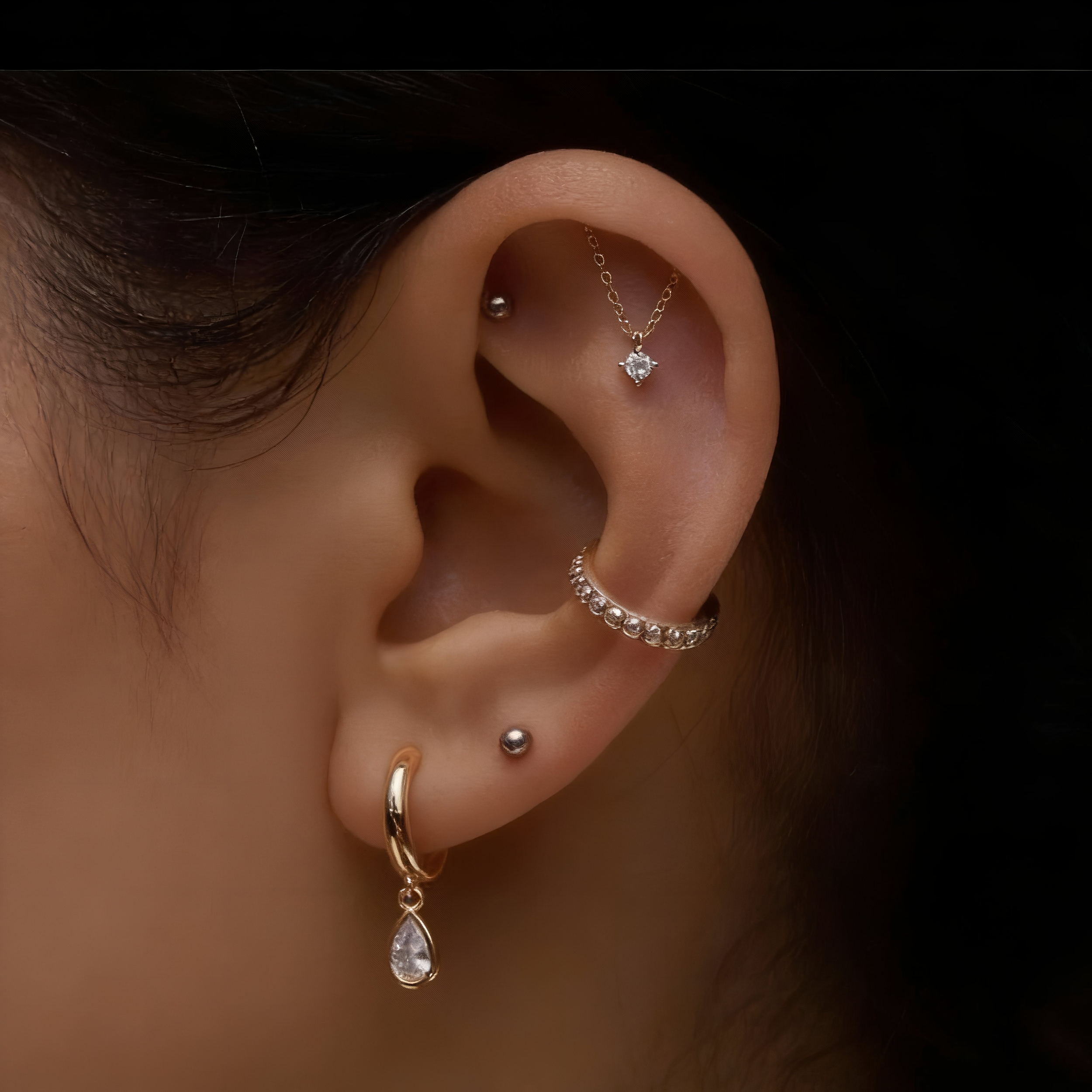 Curated ear piercing with luxury gold jewelry at Salvation Beauty Ink