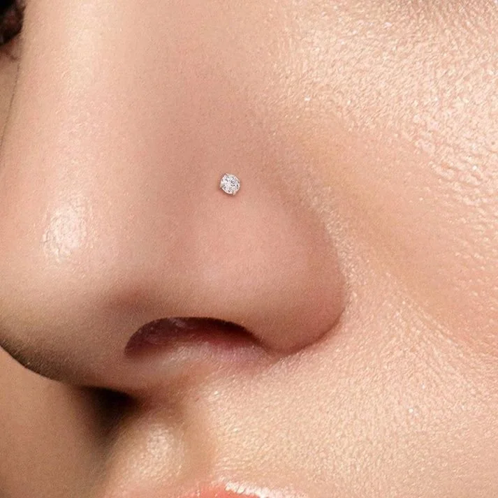 Diamond nose stud piercing on female nose at professional piercing studio in Pembroke Pines