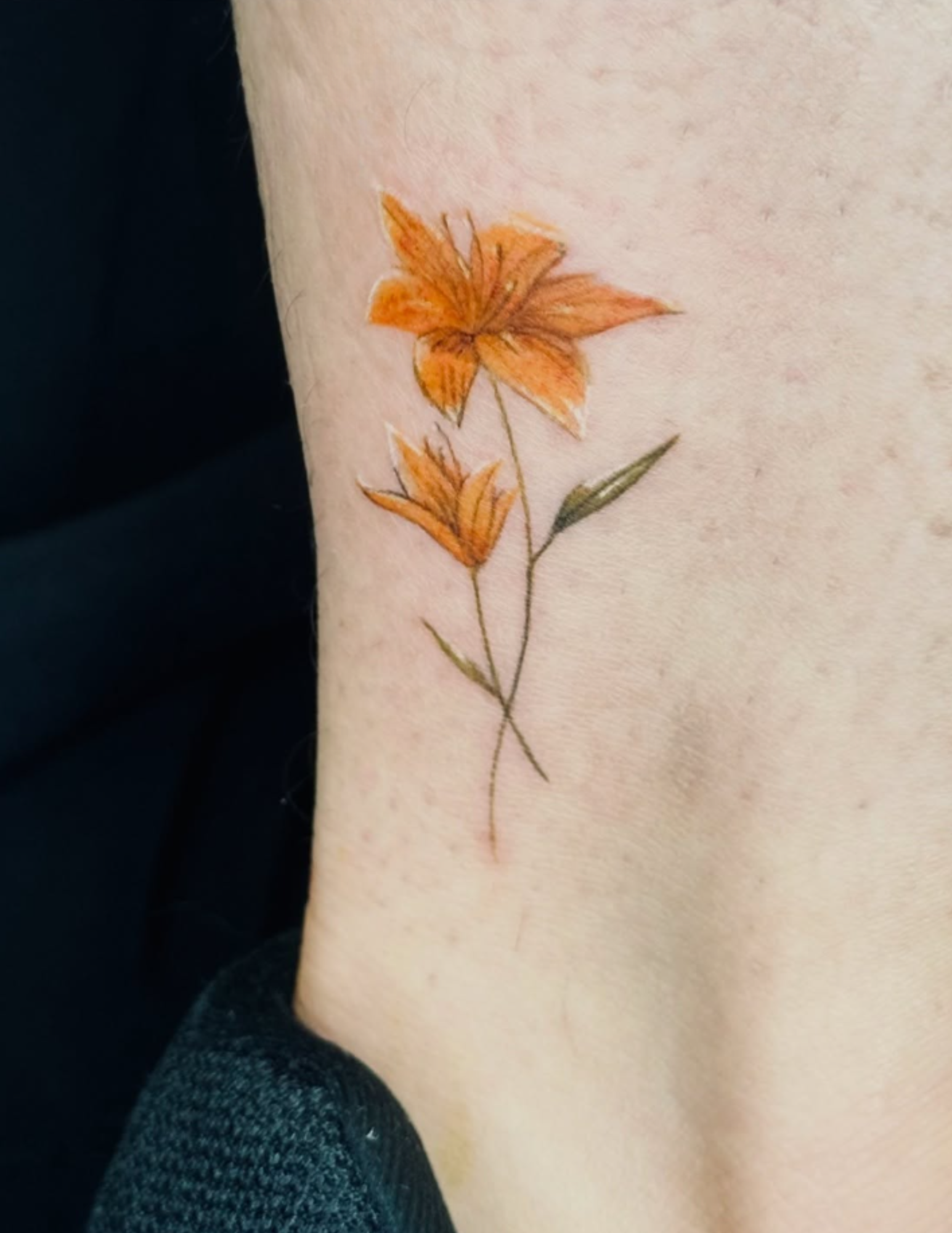 Realistic tattoo of a flower on an ankle