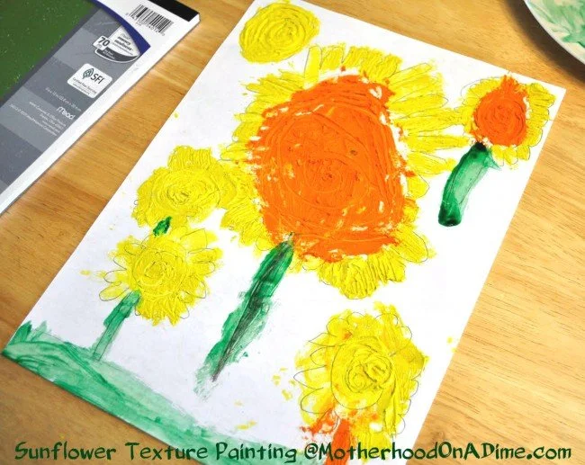 child's painting of sunflowers. A large one in the middle and three smaller ones around it.