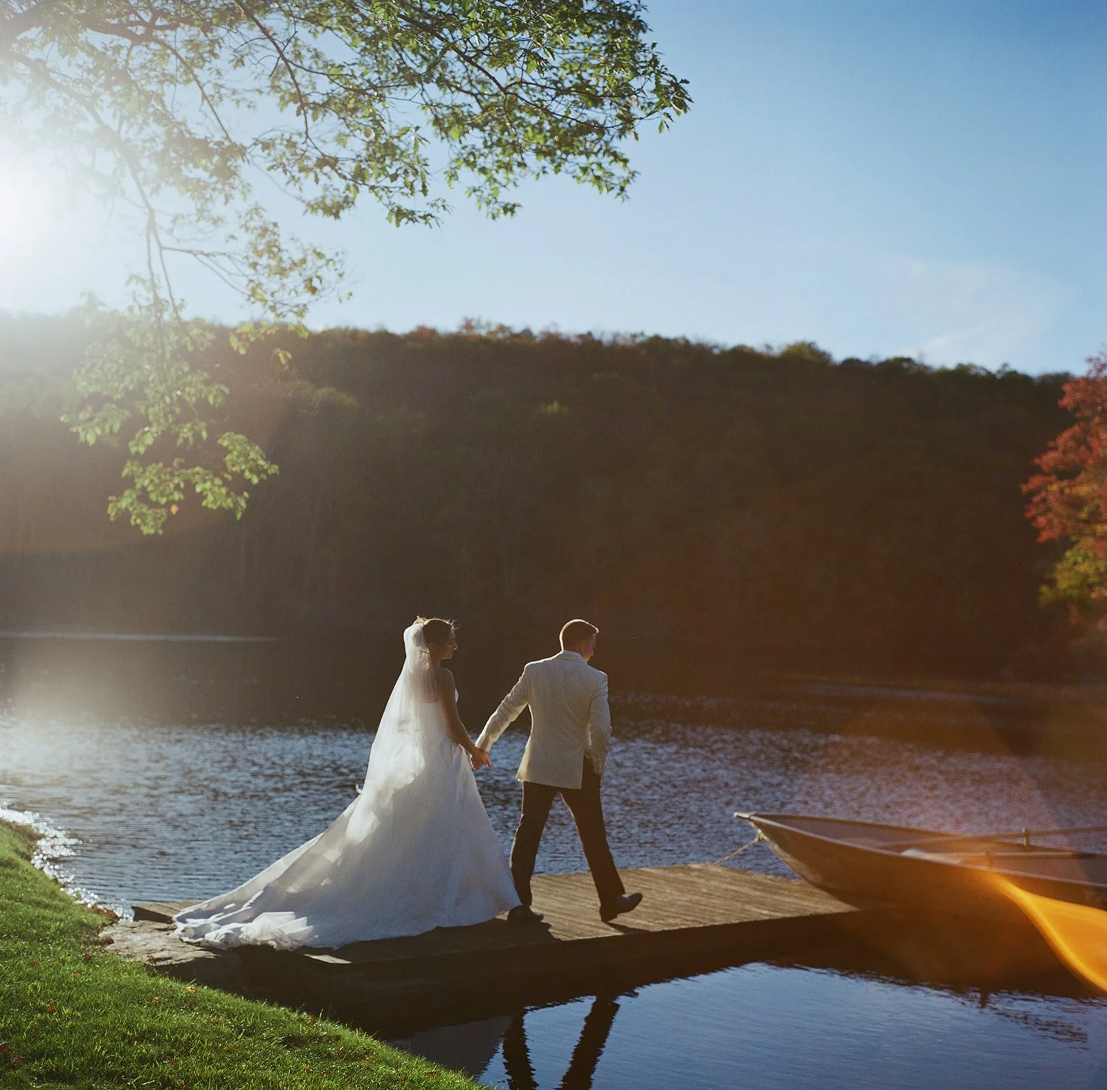 Bride and groom on the lake dock in late afternoon October light at Cedar Lakes Estate in Port Jervis, NY