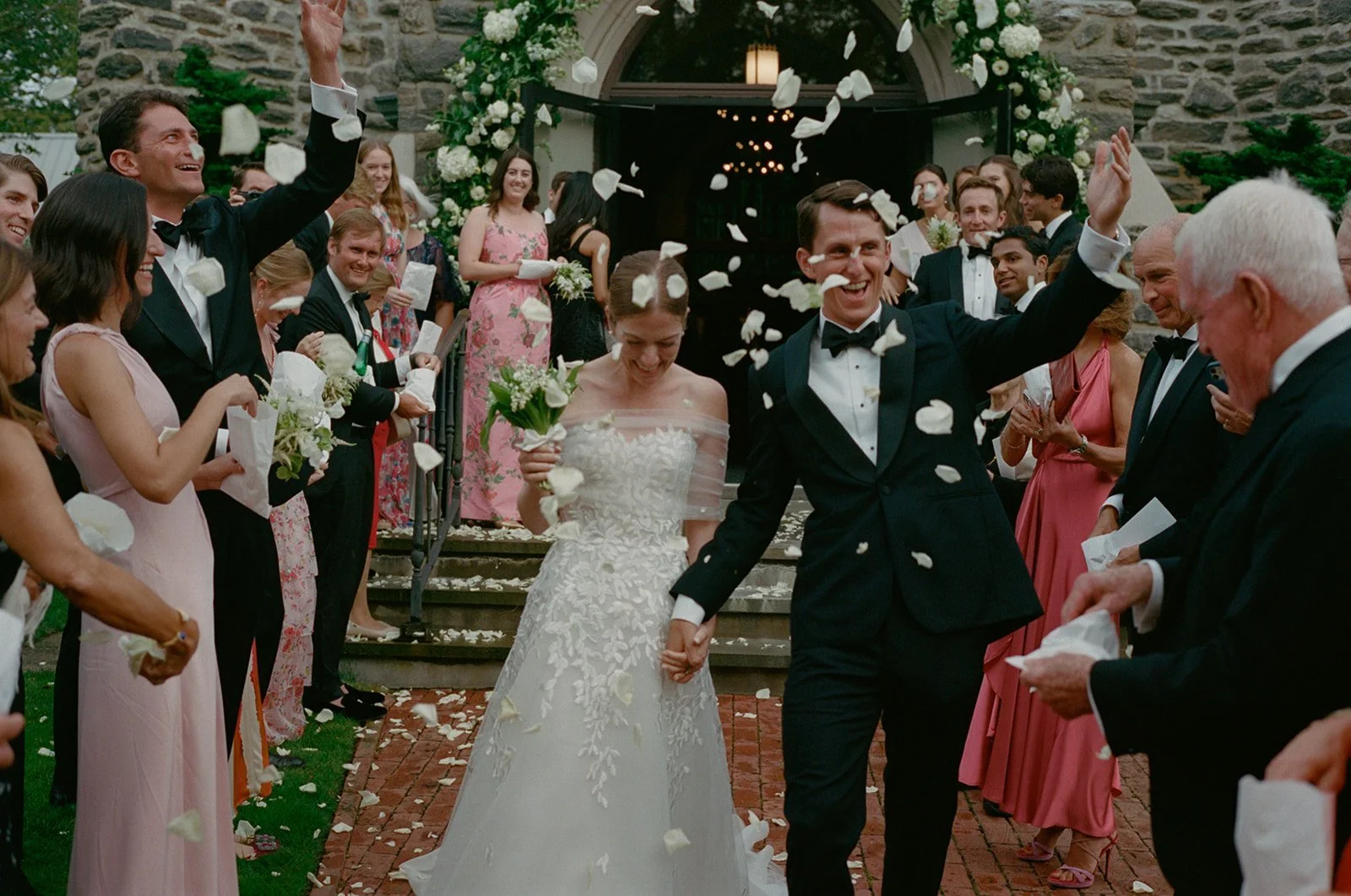 Guests throwing petals as the newlyweds leave St. Luke's Episcopal Church
