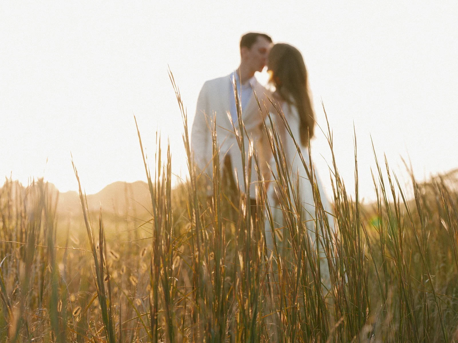 maidstone-club-wedding-venue-couple-kiss-beach-grass-sunset-07.jpg