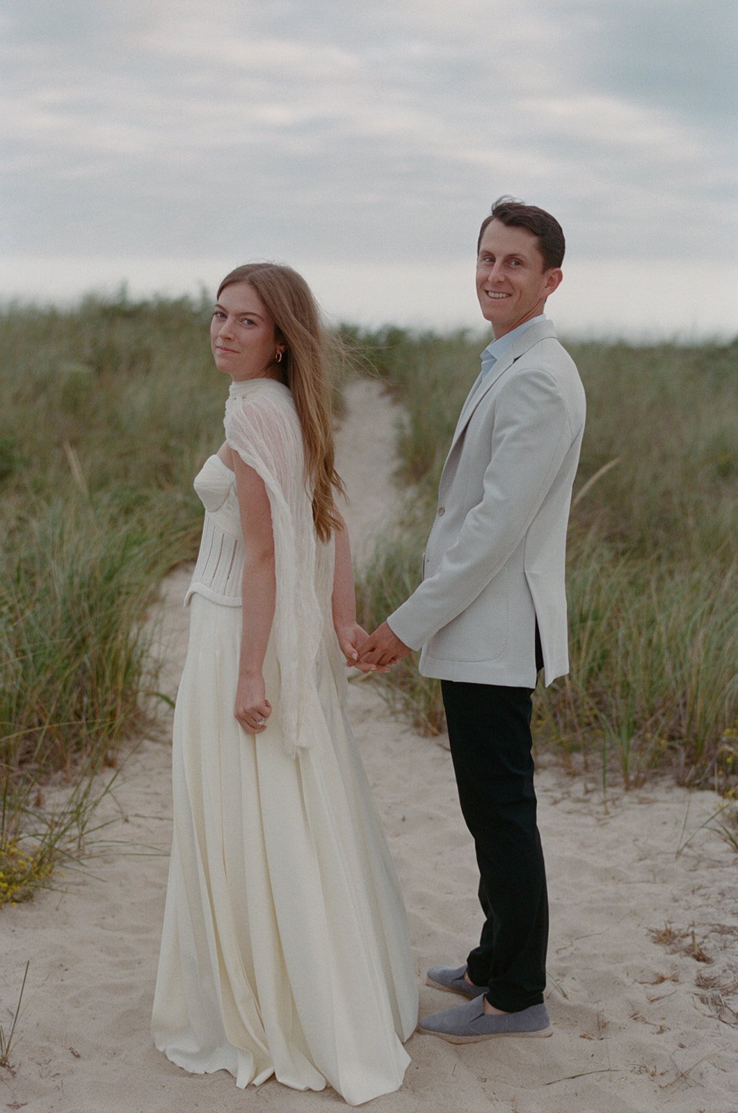 maidstone-club-wedding-venue-couple-holding-hands-dunes-02.jpg