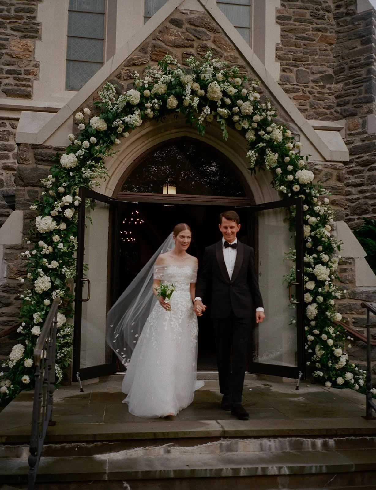 st-lukes-east-hampton-wedding-couple-under-floral-arch-03.jpg