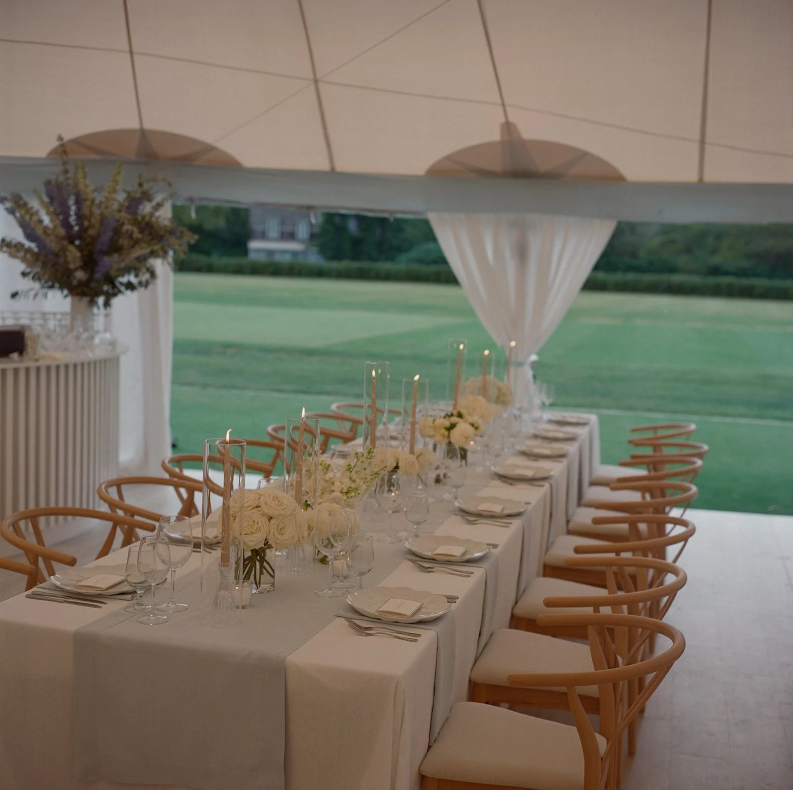 Long reception table facing the golf course from the tent at The Maidstone Club