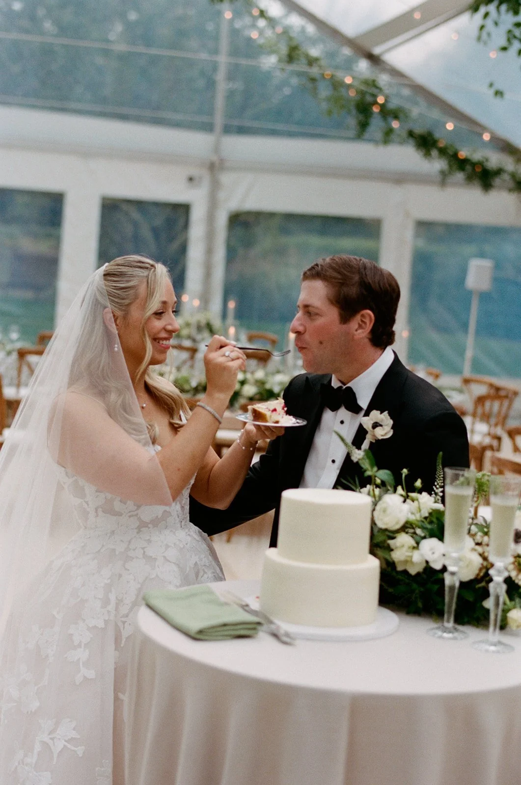Bride feeding the groom cake in the empty tent before guests arrive