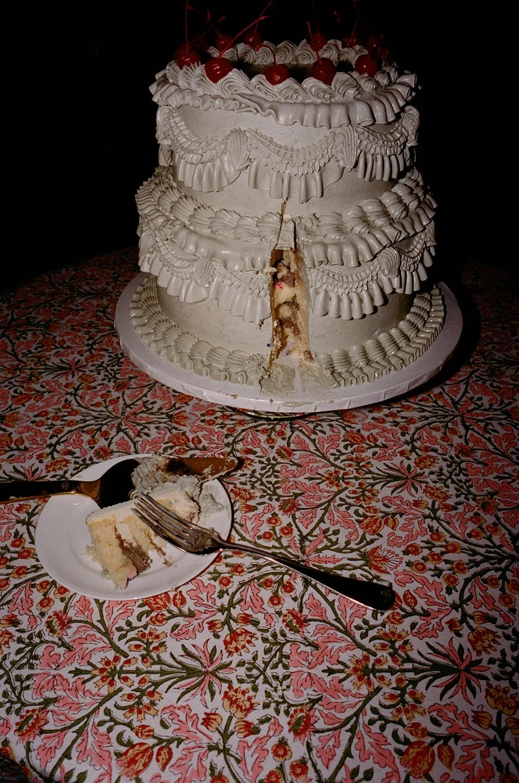 Ruffled white cake with a slice missing on a floral tablecloth at The Standard, High Line