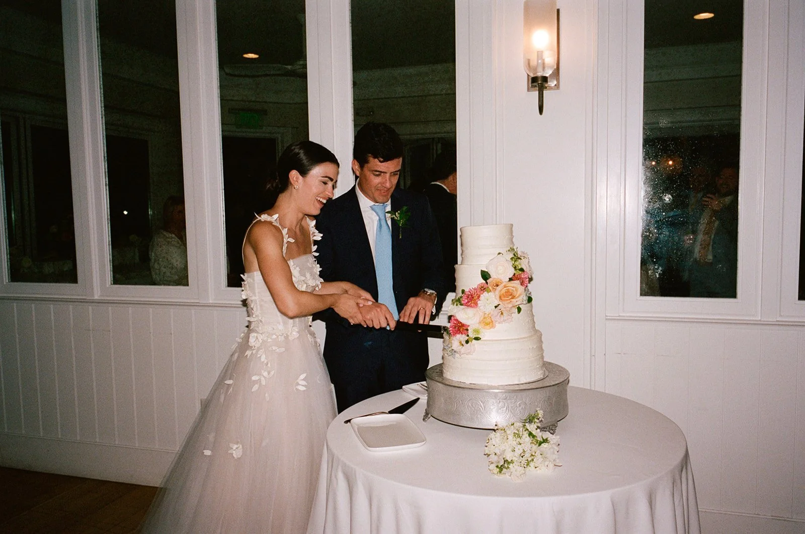 Bride and groom cutting a four-tier floral cake at Chatham Bars Inn