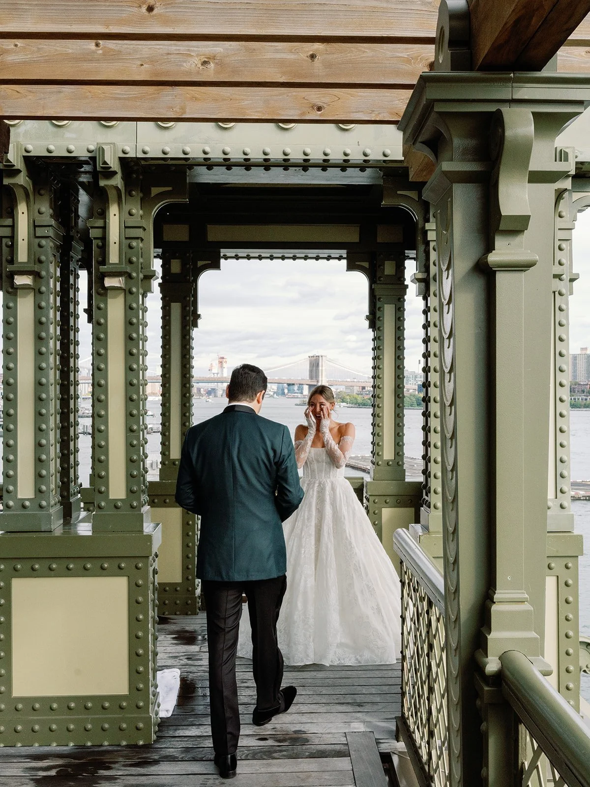 Bride tearing up as the groom walks toward her on the Casa Cipriani pier, Brooklyn Bridge behind them