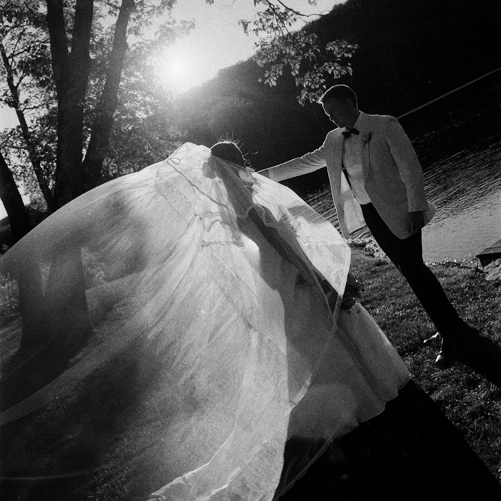 Black and white photo of the bride's veil catching the sun beside the groom at Cedar Lakes Estate in Port Jervis, NY