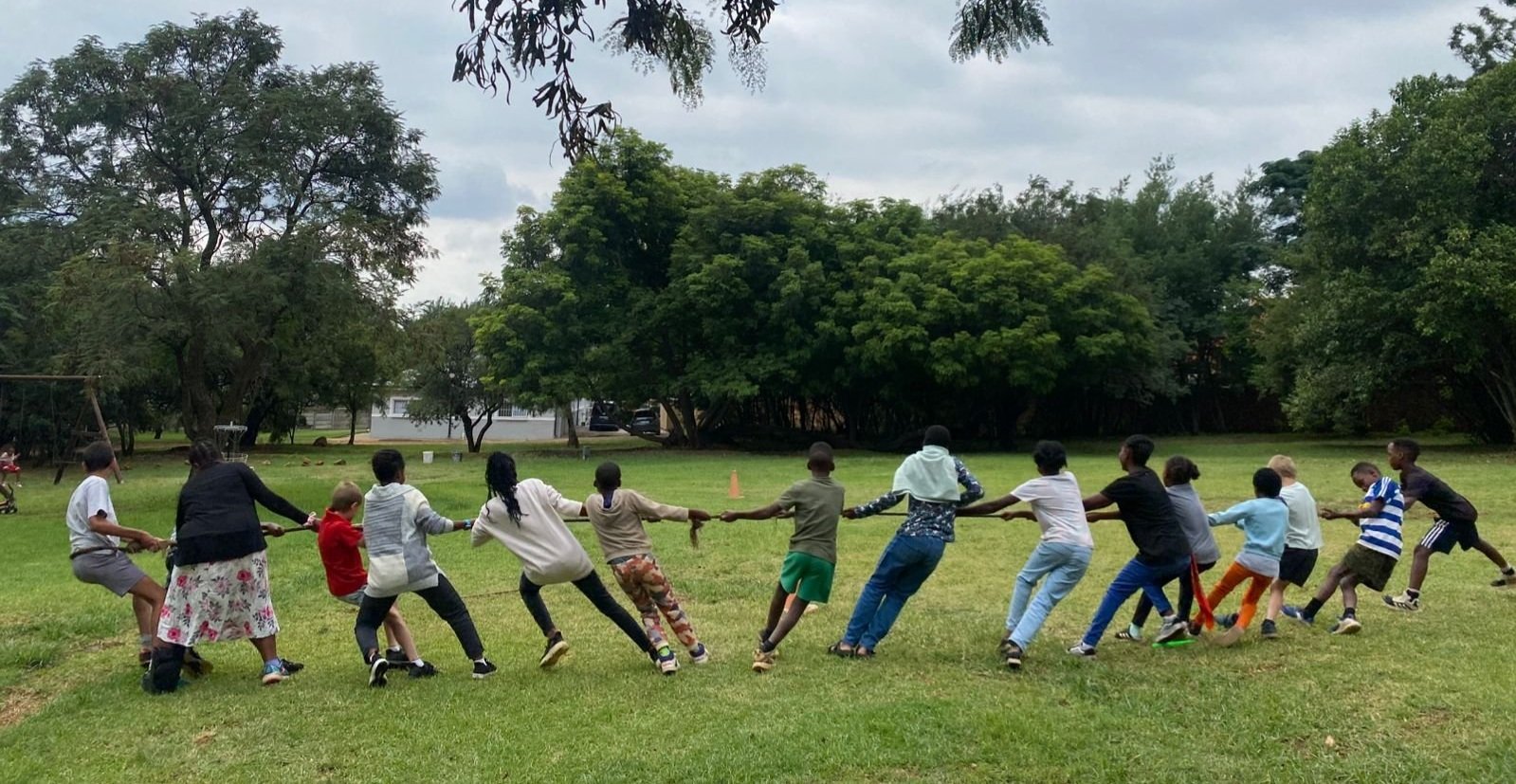 African children playing tug of war in an open field