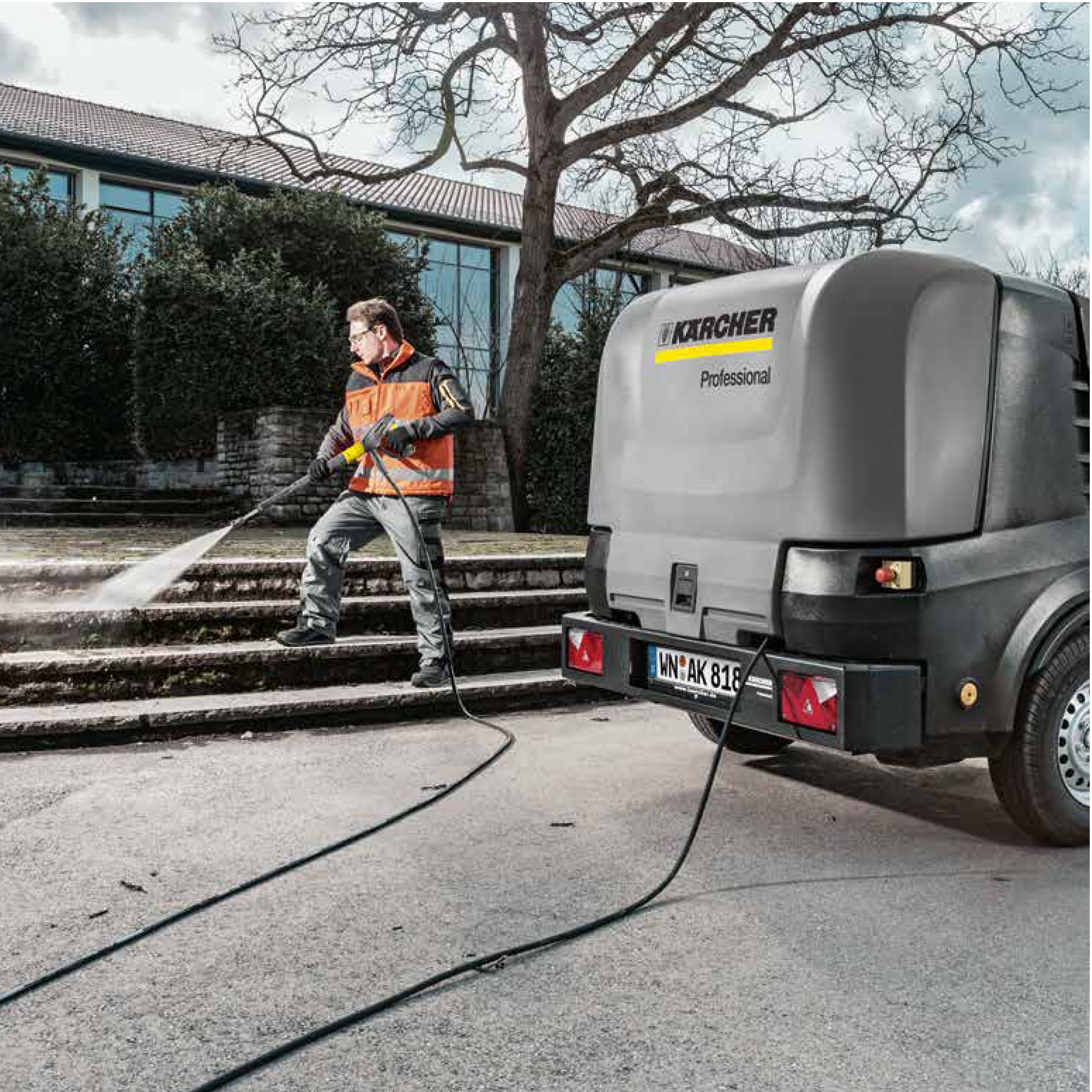 En mann i Uniform vasker trappen med høytrykksvaskemaskin fra Kärcher.