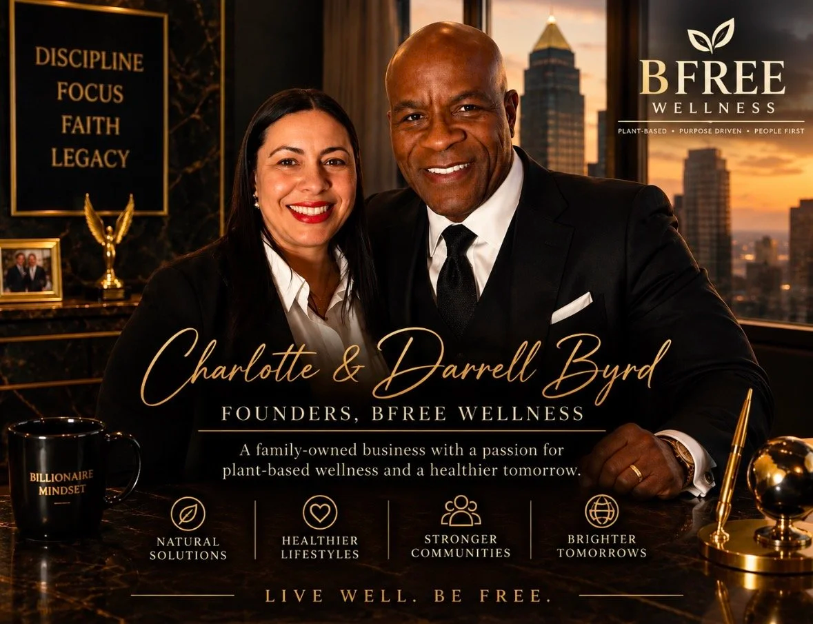 A promotional image for BFREE Wellness featuring Charlotte and Darrell Byrd, the founders, with city buildings visible through a window in the background. They are dressed in formal business attire, smiling at the camera, with wellness and business-themed items on the desk.