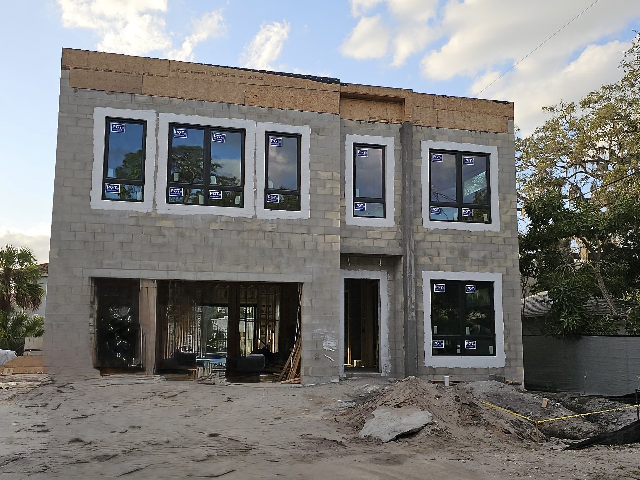 Partially constructed two-story house with cement blocks and multiple windows