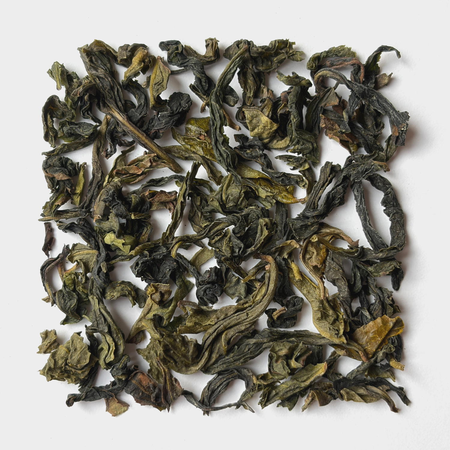 Getrocknete grüne Teeblätter auf weißem Hintergrund