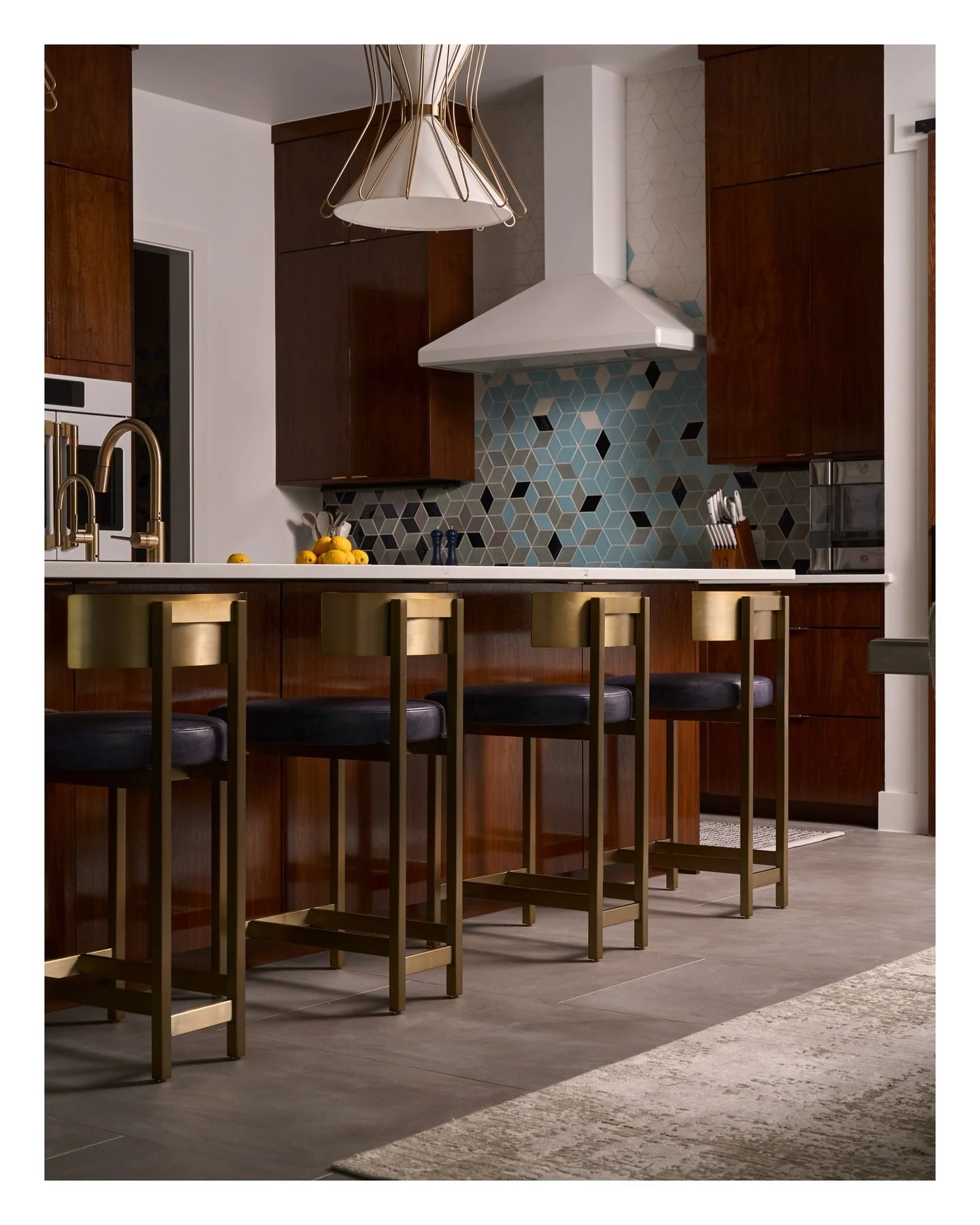 A beautiful, thoughtfully layered kitchen by Shared Treasures Design.

Rich walnut cabinetry, warm brass details, and a striking blue geometric tile backsplash come together to create a space that feels both refined and welcoming. Every material and 
