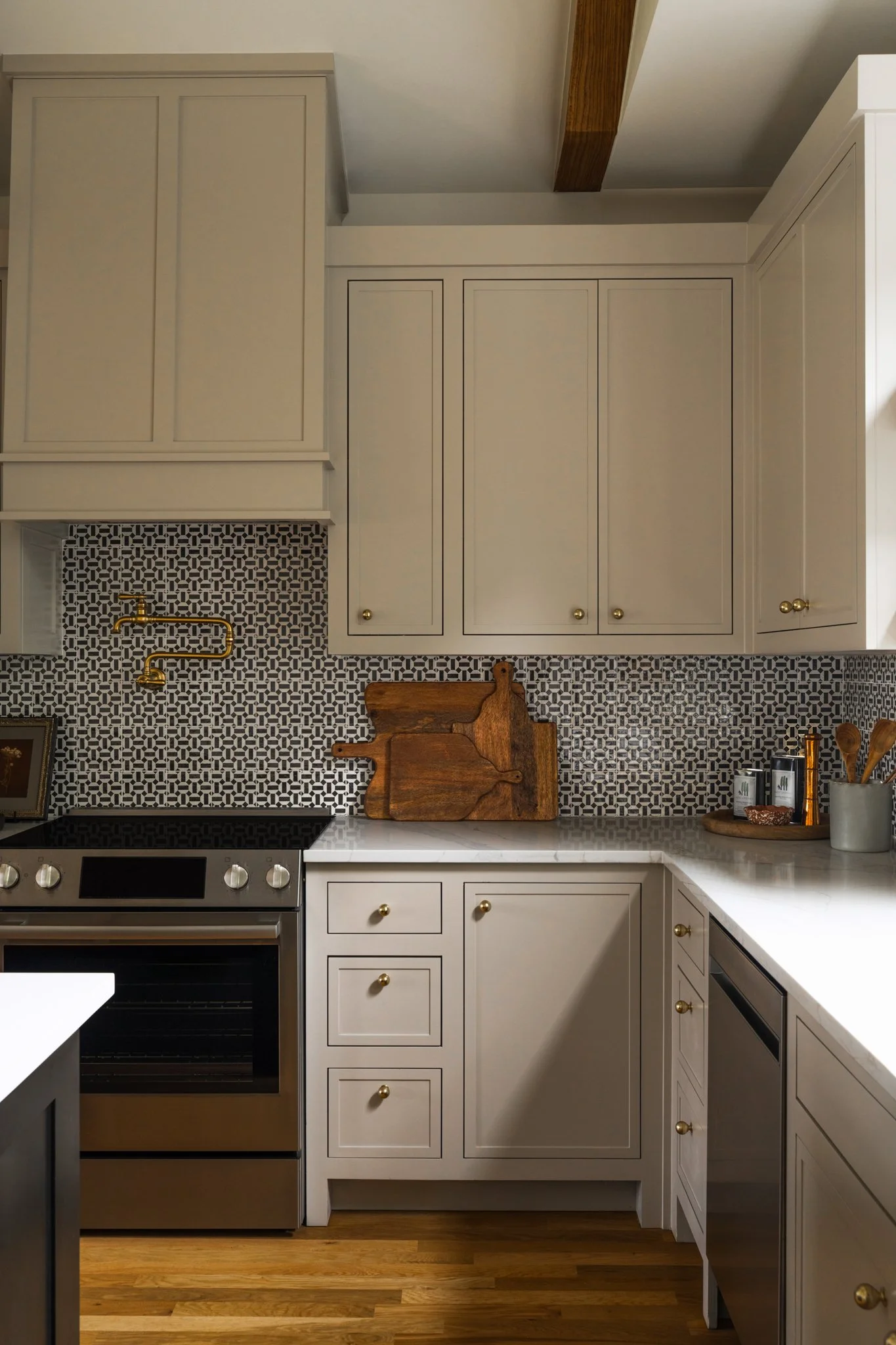 Kitchen with white cabinets, a patterned backsplash, wooden countertop, and various kitchen items including cutting boards, utensils, and a framed picture.