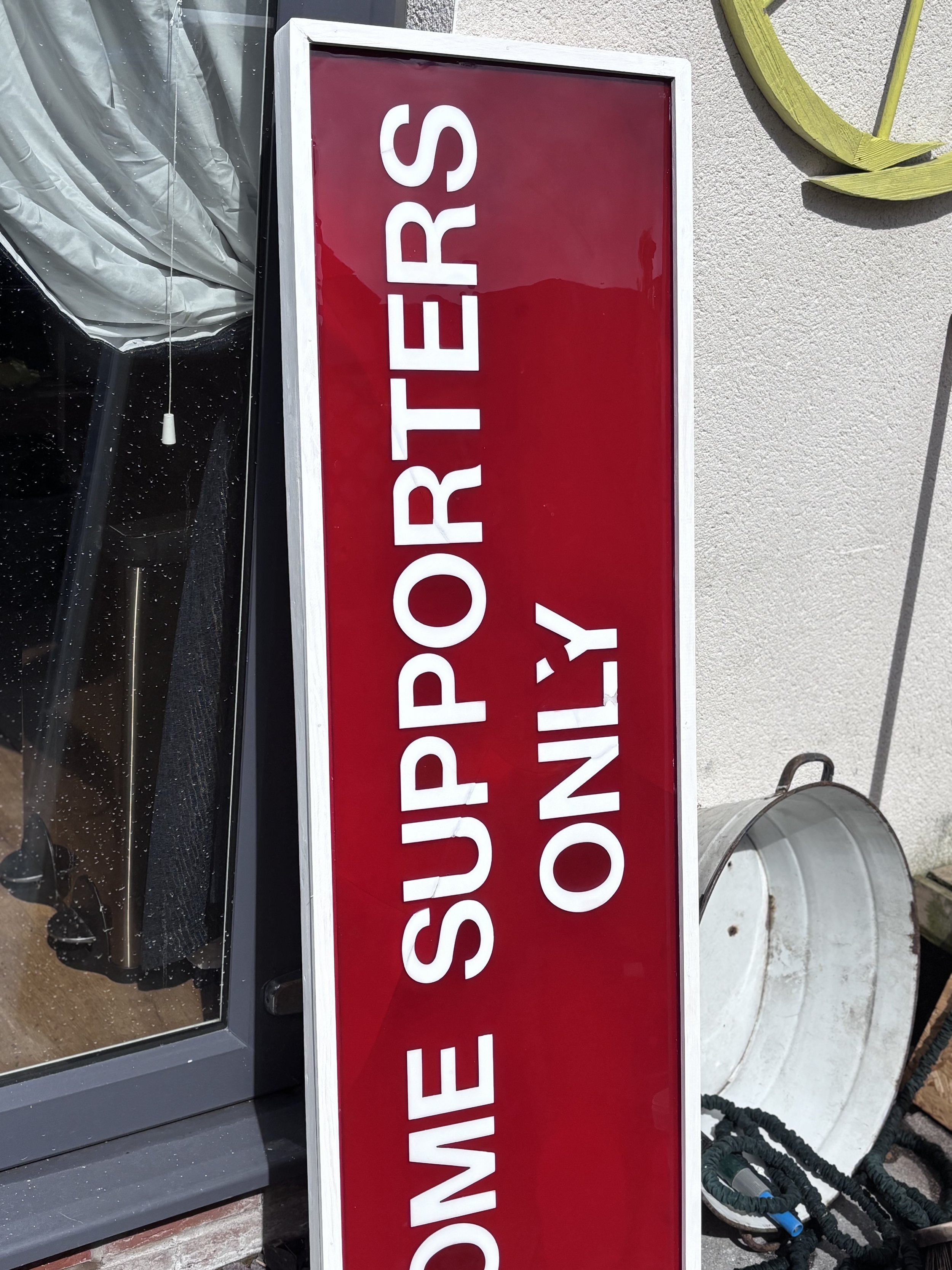 Red and white sign that says 'HOME SUPPORT OPERATIONS ONLY' in front of a building.