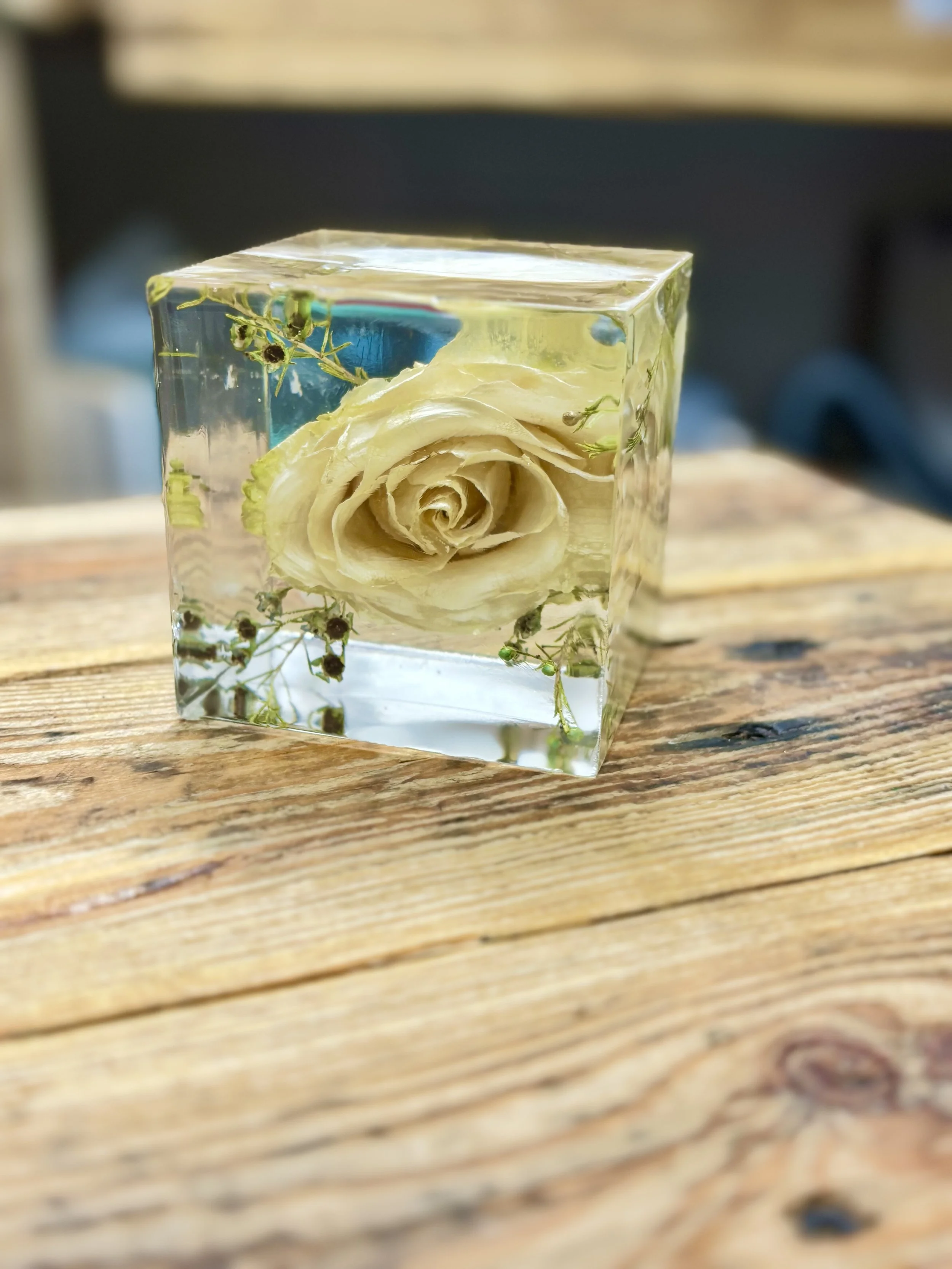 Pale rose and small flowers arranged inside a bespoke clear resin cube by Really Resin.