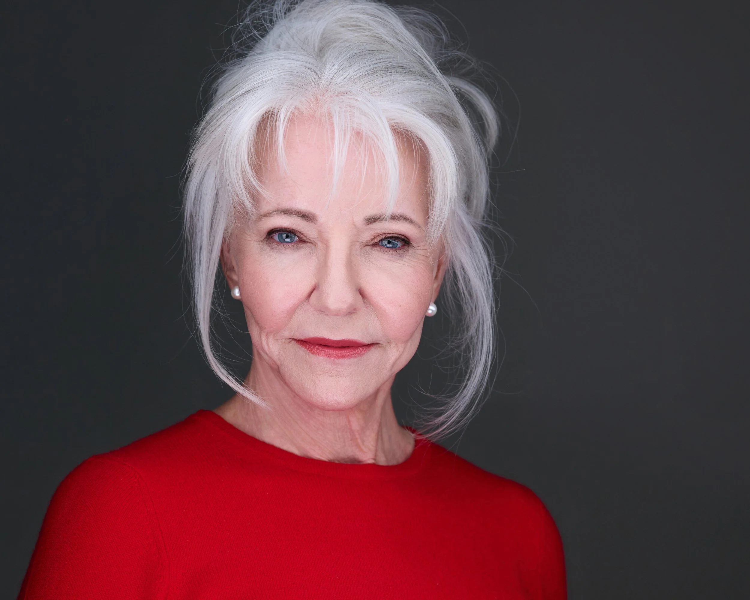 Professional Headshot of a mature woman with white hair and a red shirt