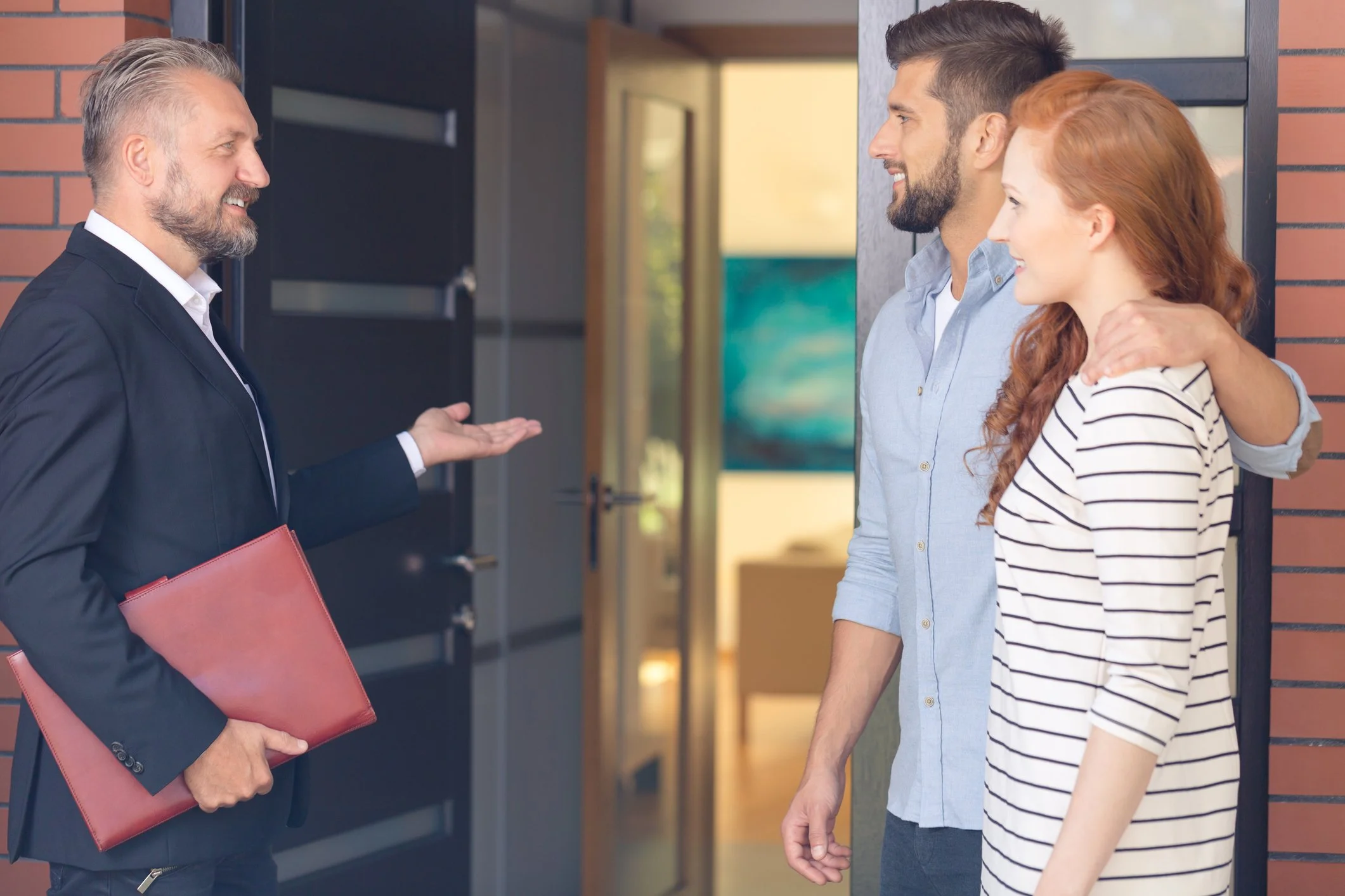 Doradca Maxbud omawia ofertę budowy domu i montażu okien z klientami przed ich nowym domem