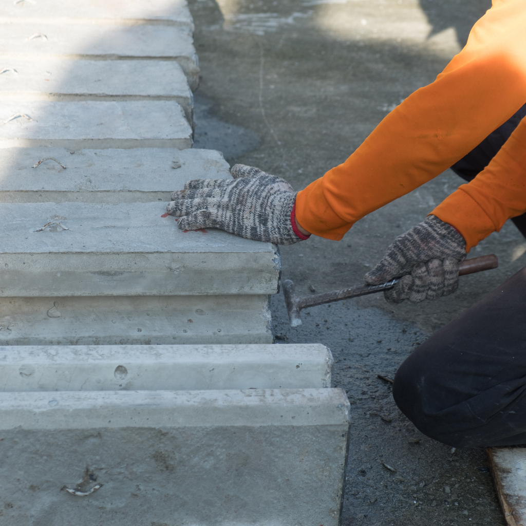 Worker wearing safety gloves and repairing concrete steps