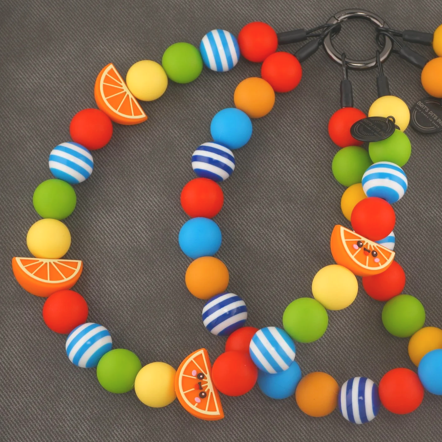 Main Squeeze - Stylish beaded dog collars and necklaces with orange slice accents, blue strips, green, yellow, and red.