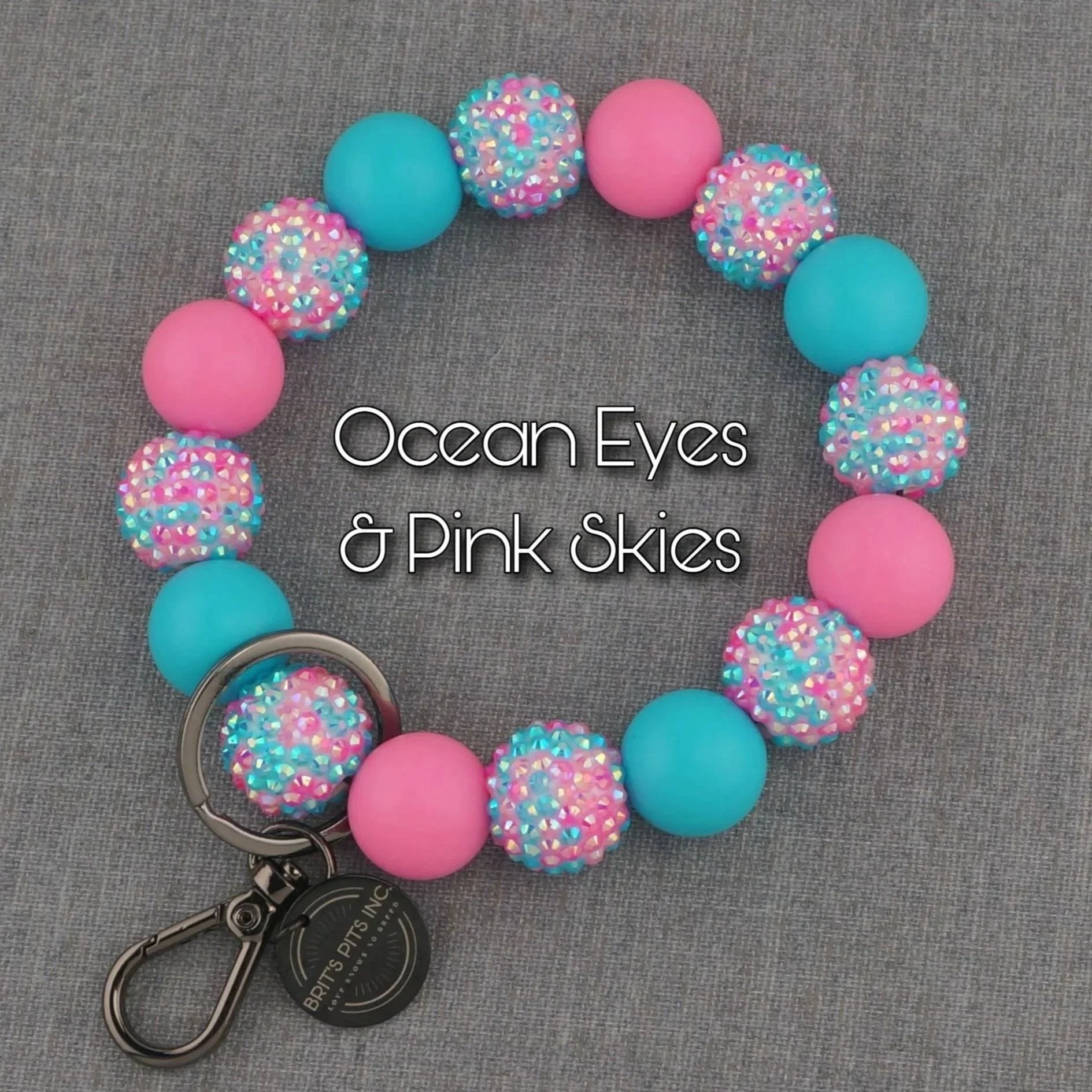 Ocean Eyes & Pink Skies beaded wristlet keychain.  Silicone and acrylic beads in bright pink and blue with sparkling rhinestones.