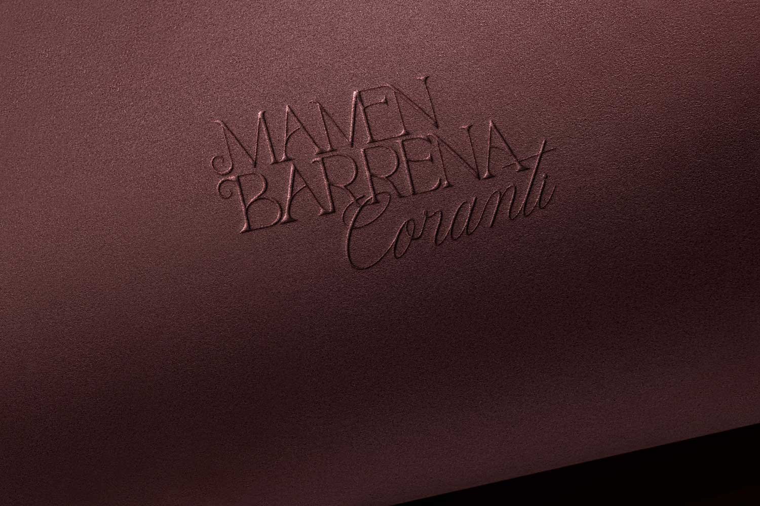 Logotipo de Mamen Barrena Coranti aplicado con técnica de grabado en seco sobre papel de alta calidad color granate.