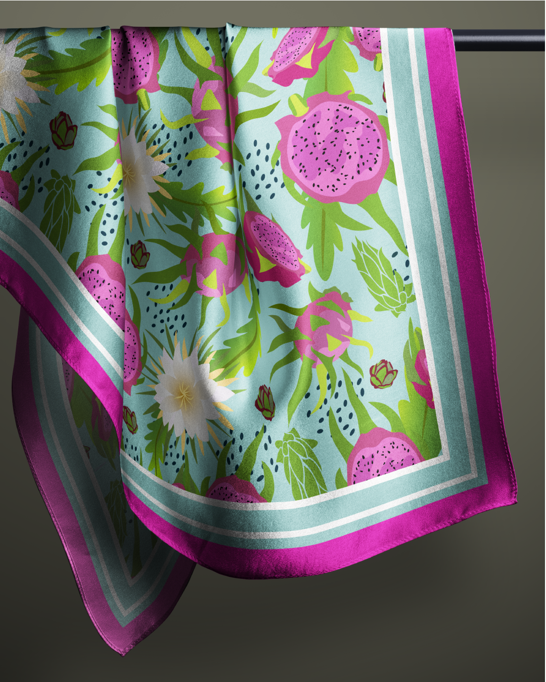 Pañuelo de seda estampado con flores y frutas, principalmente pitahayas, con bordes morados sobre fondo azul.