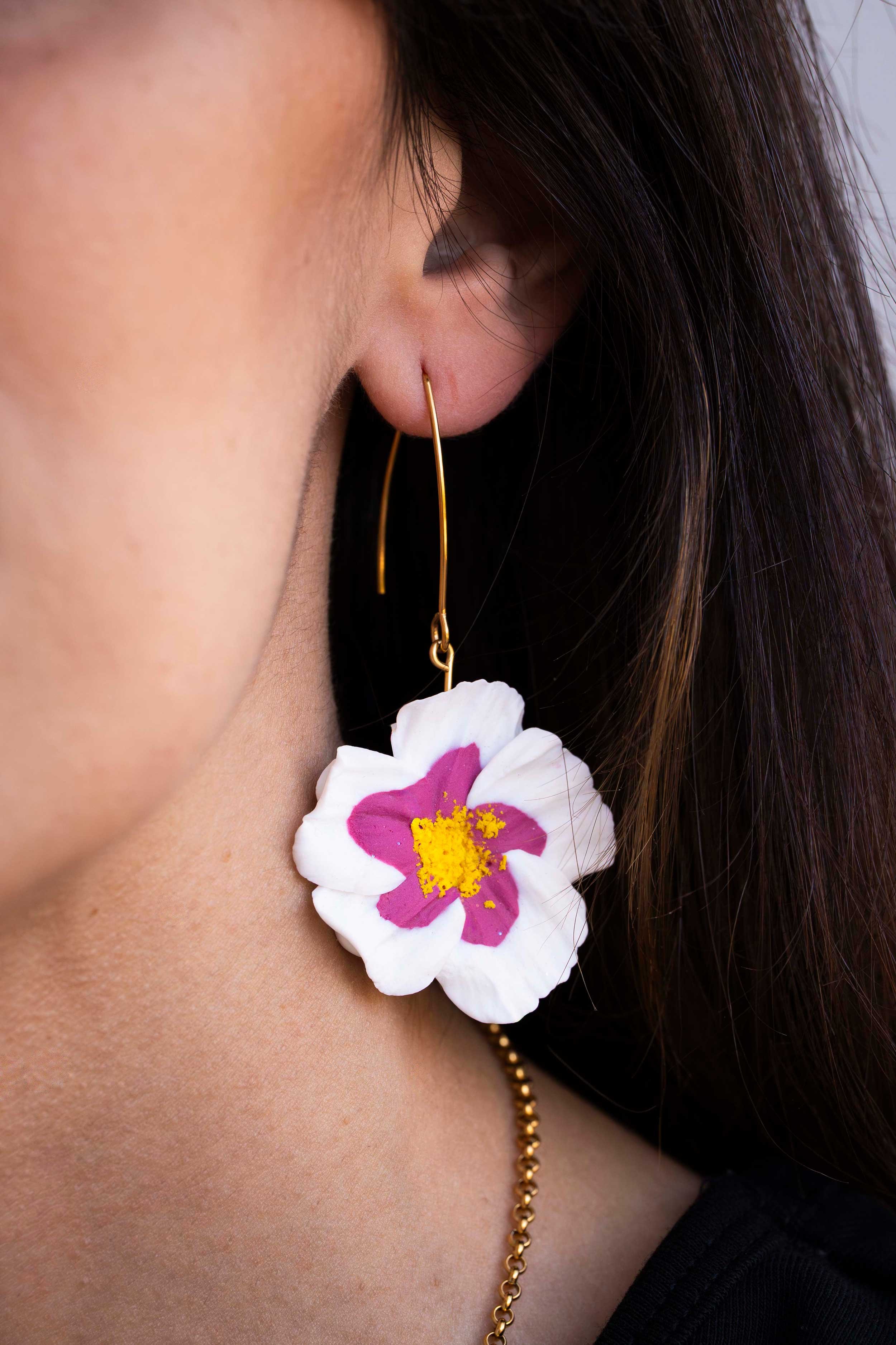 Pendiente de diseño artesanal en forma de flor blanca y fucsia una pieza de joyería de autor de la marca Meridia.