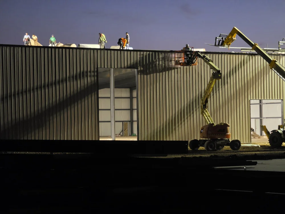 Roof insulation crew at dawn on a PEMB data center support building