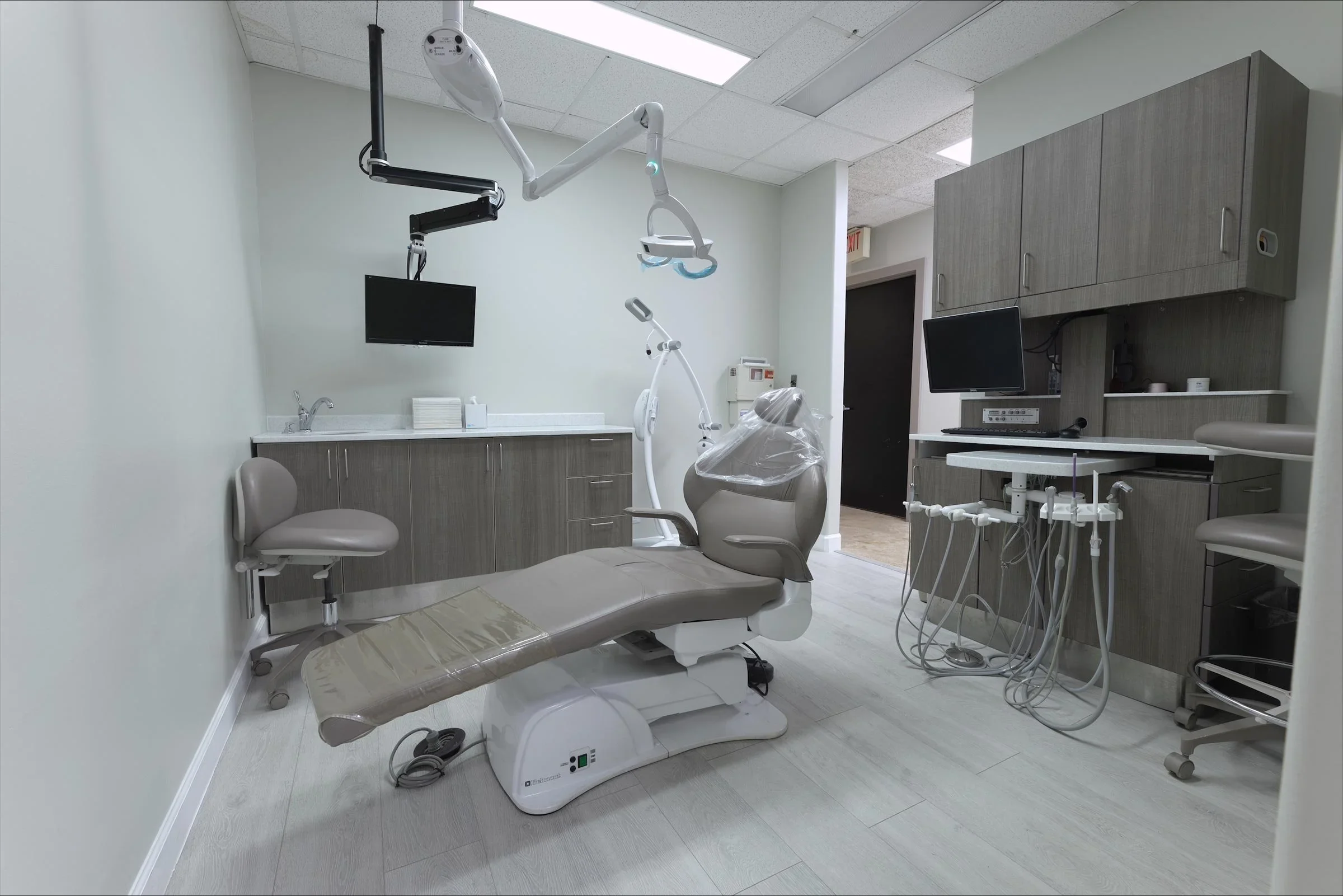 Modern dental office with chair, equipment, and monitors. TCG Medical Construction Project.